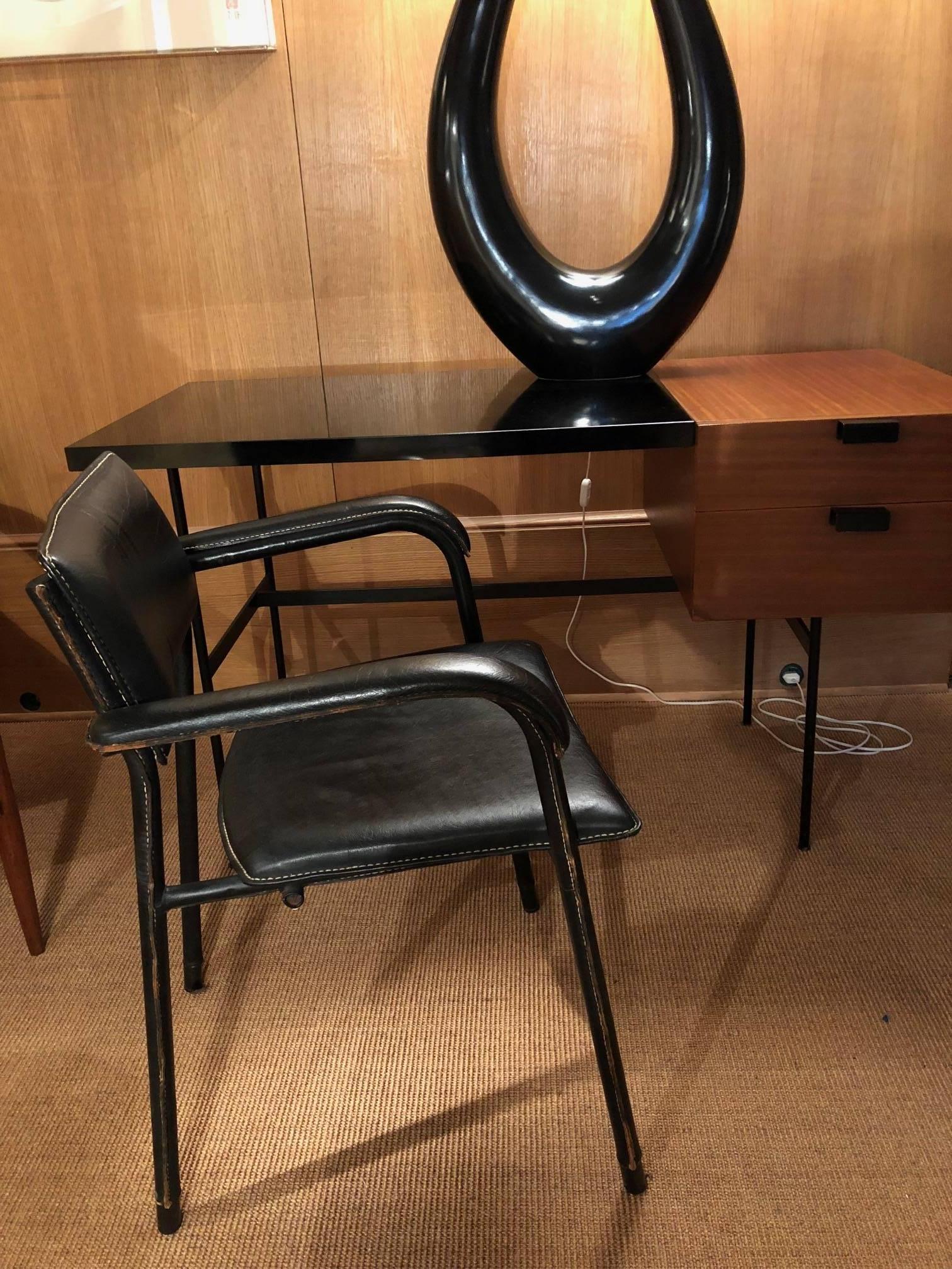 Jacques Adnet desk armchair in its original black leather cover, very rare in this condition which is a precious testimony of the quality of Adnet's work.
Vintage black leather hand-stitched piqué-sellier, tubular metal structure gained with