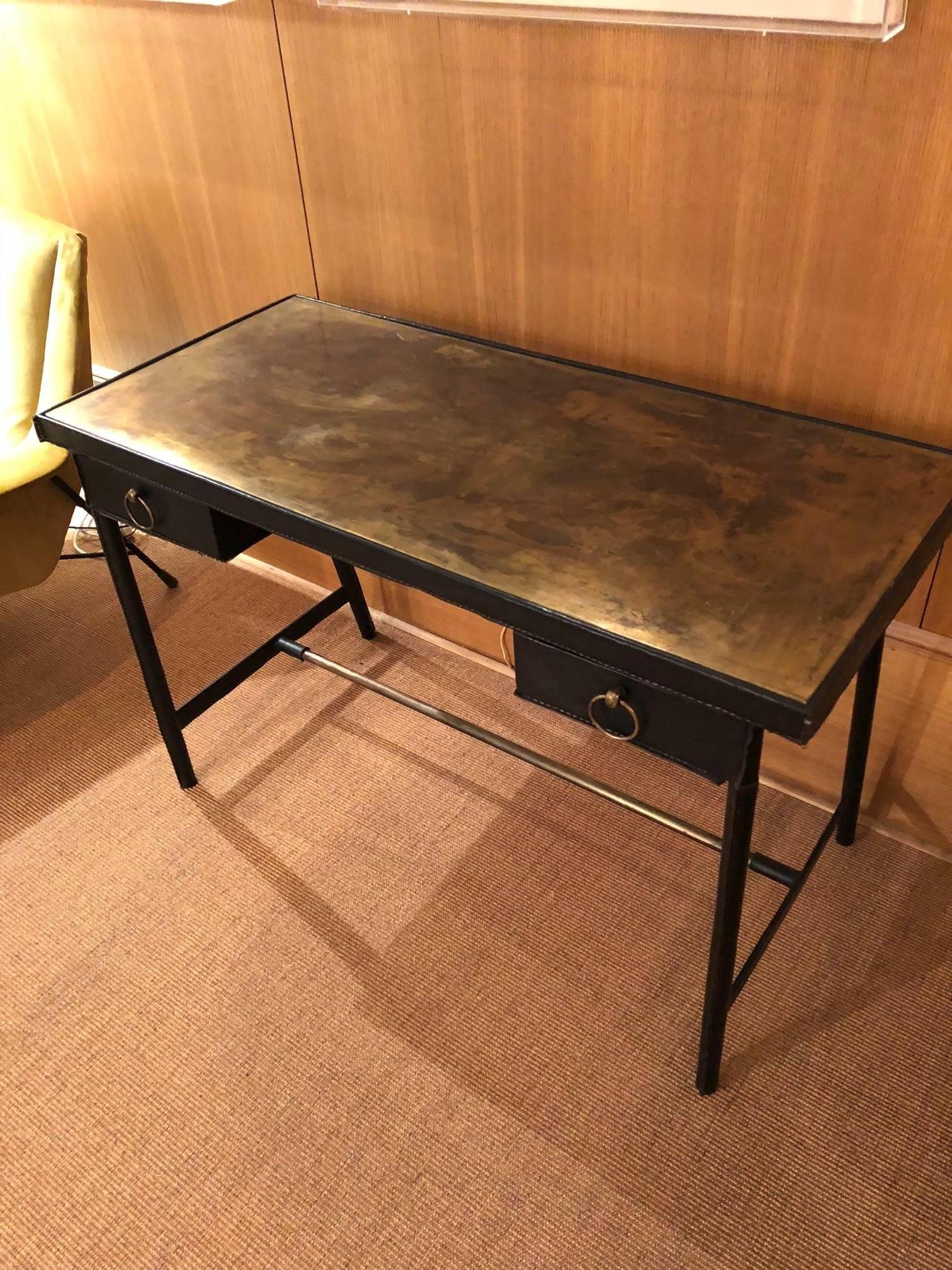 Jacques Adnet desk in its original black leather cover and brass shelf, very rare.
Vintage black leather hand-stitched piqué-sellier, tubular metal structure gained with leather.
Typical work of the 1950s.