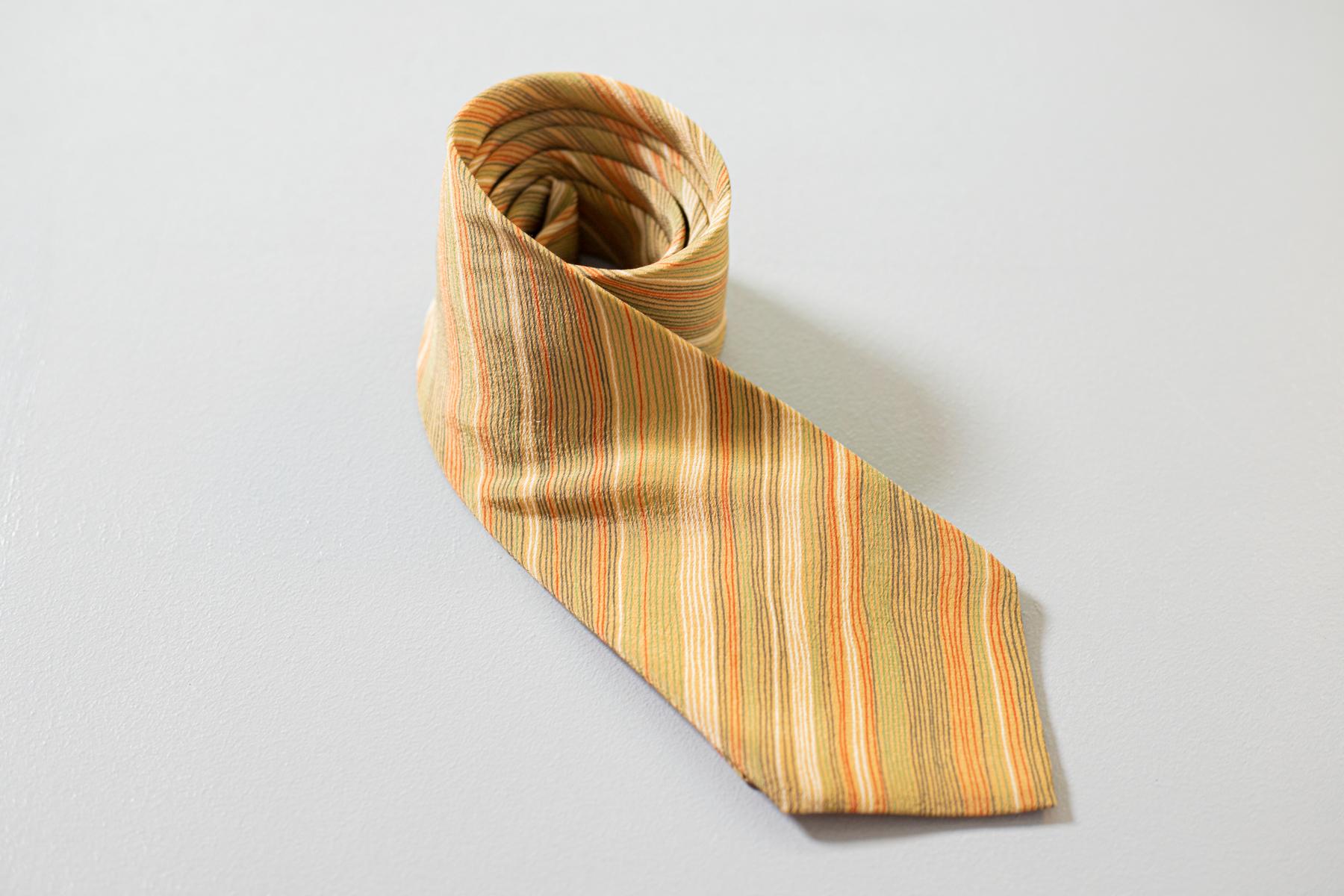 Refined and elegant, this vintage tie is designed by Jacques Lavas. It is made of silk, decorated with small lines of various shades of yellow. Classic but never banal, ideal for lovers of taste and formal look. Ideal to combine with a solid color