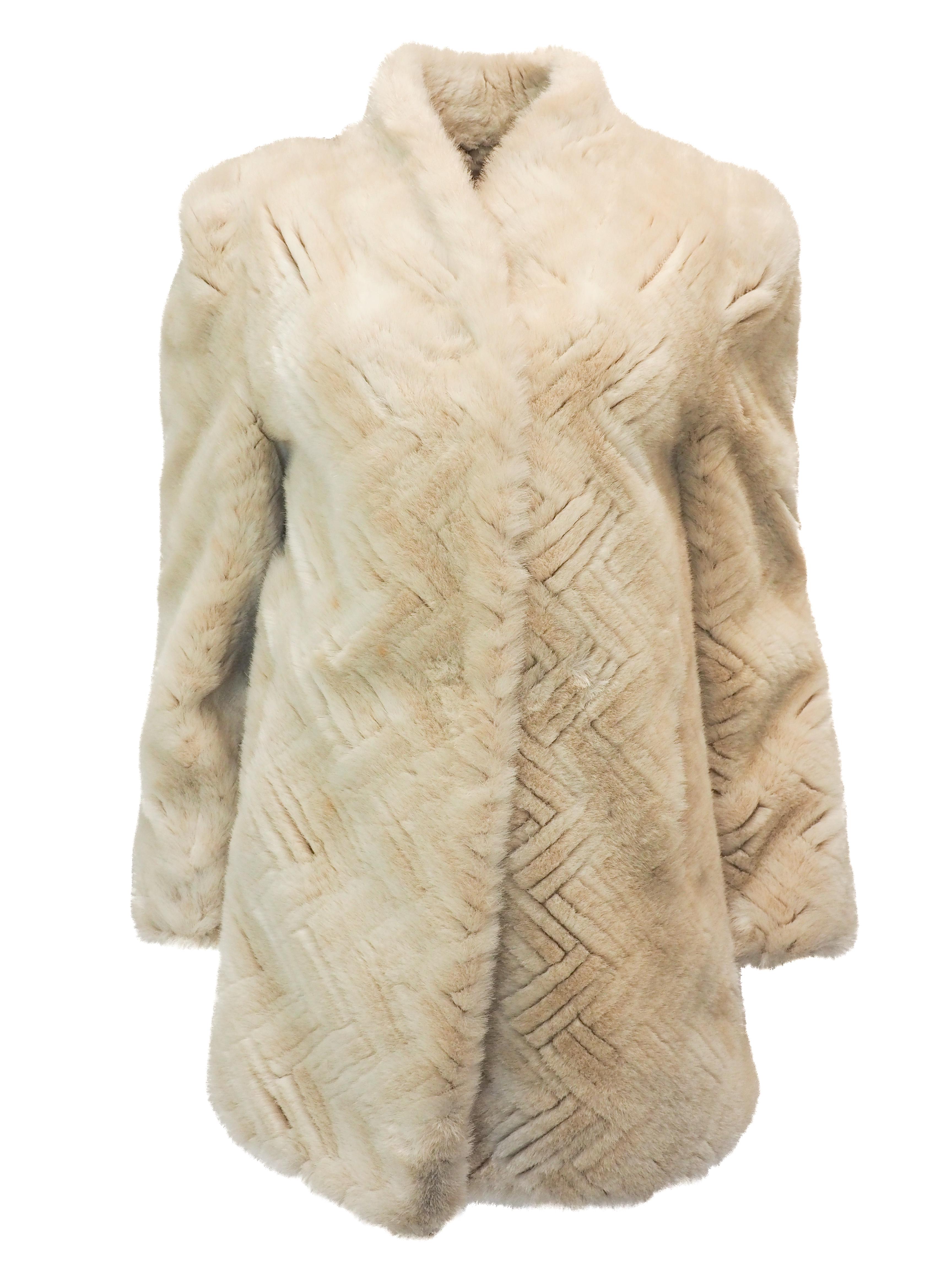A timeless vintage treasure from Jacques Saint Laurent, this ivory fur coat showcases an striking geometric pattern that elevates classic elegance. The structured silhouette provides effortless layering through winter months, draping beautifully