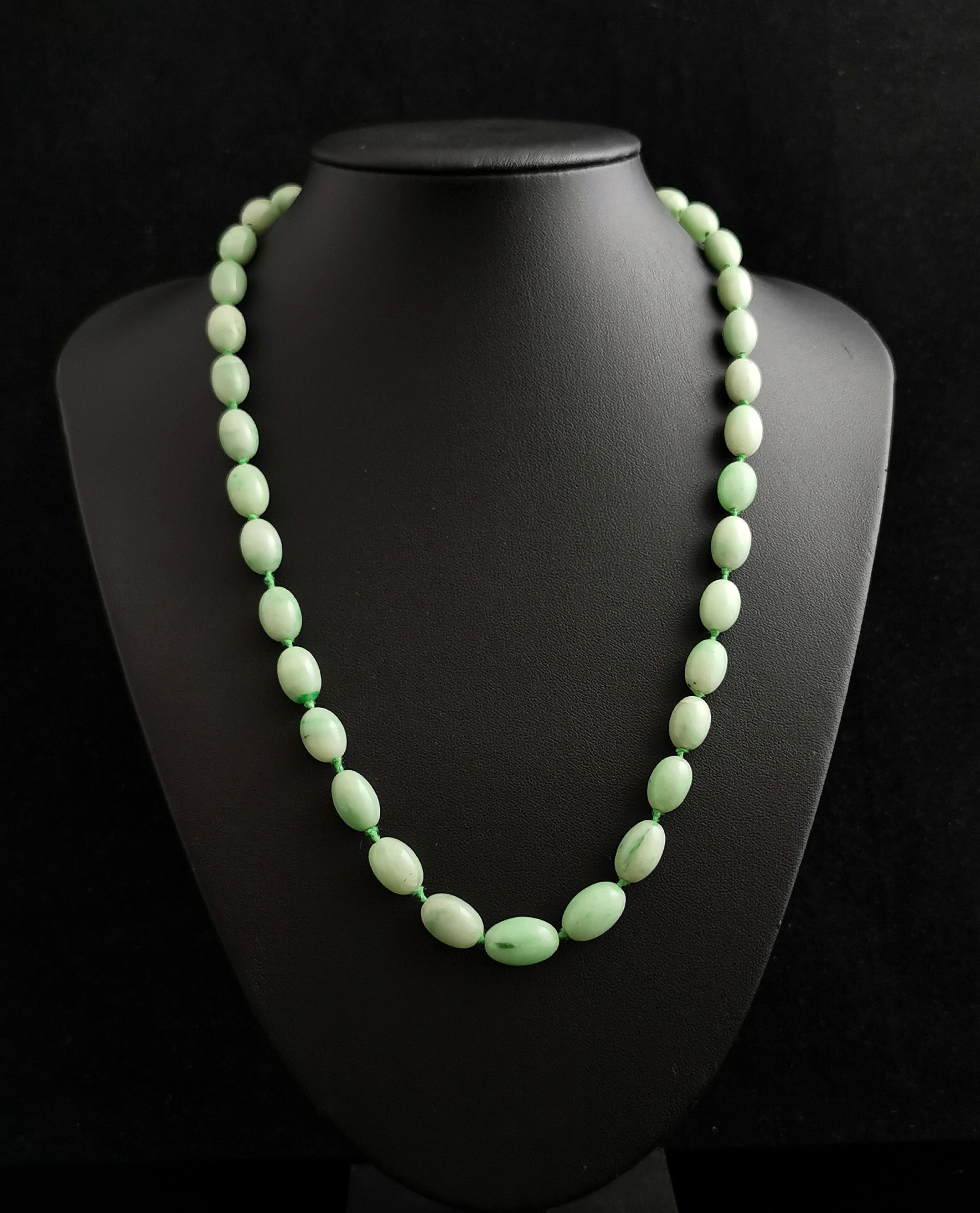 A beautiful vintage Art Deco era Jadeite Jade bead necklace.

Lovely minty green beads, with beautiful variations in the colourway from almost white to darker streaks and naturally occurring spots within, all delicately hand shaped and tightly