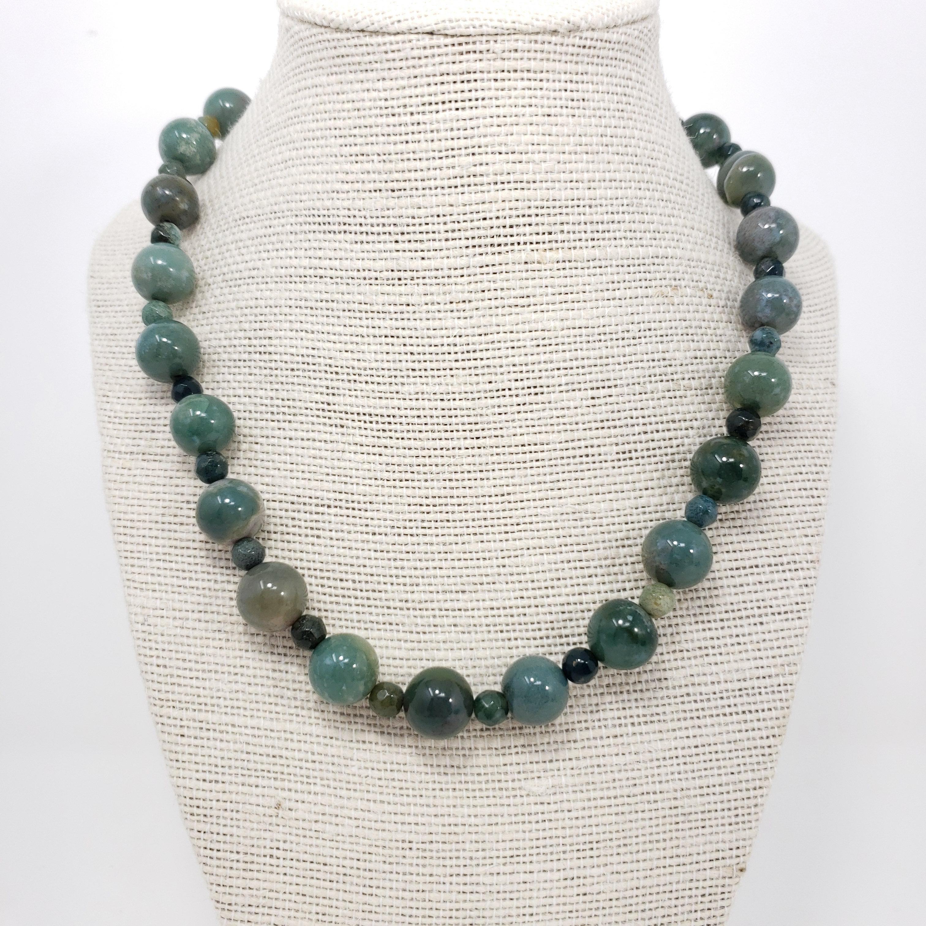 A sophisticated jade bead necklace, featuring alternating polished and faceted jade beads fastened with a vintage, sterling silver, hook clasp.