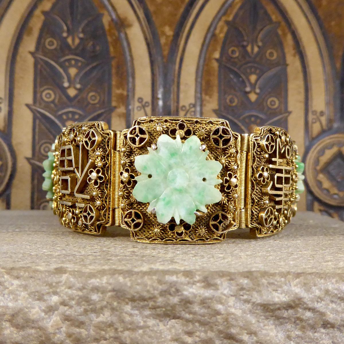 This gorgeous vintage bracelet features 7 panels of Gold Plated Chinese Silver with floral details that delicately decorate each panel. Starting with the first panel adorned and fixed with a carved Jadeites in a flower pattern, leading to the next