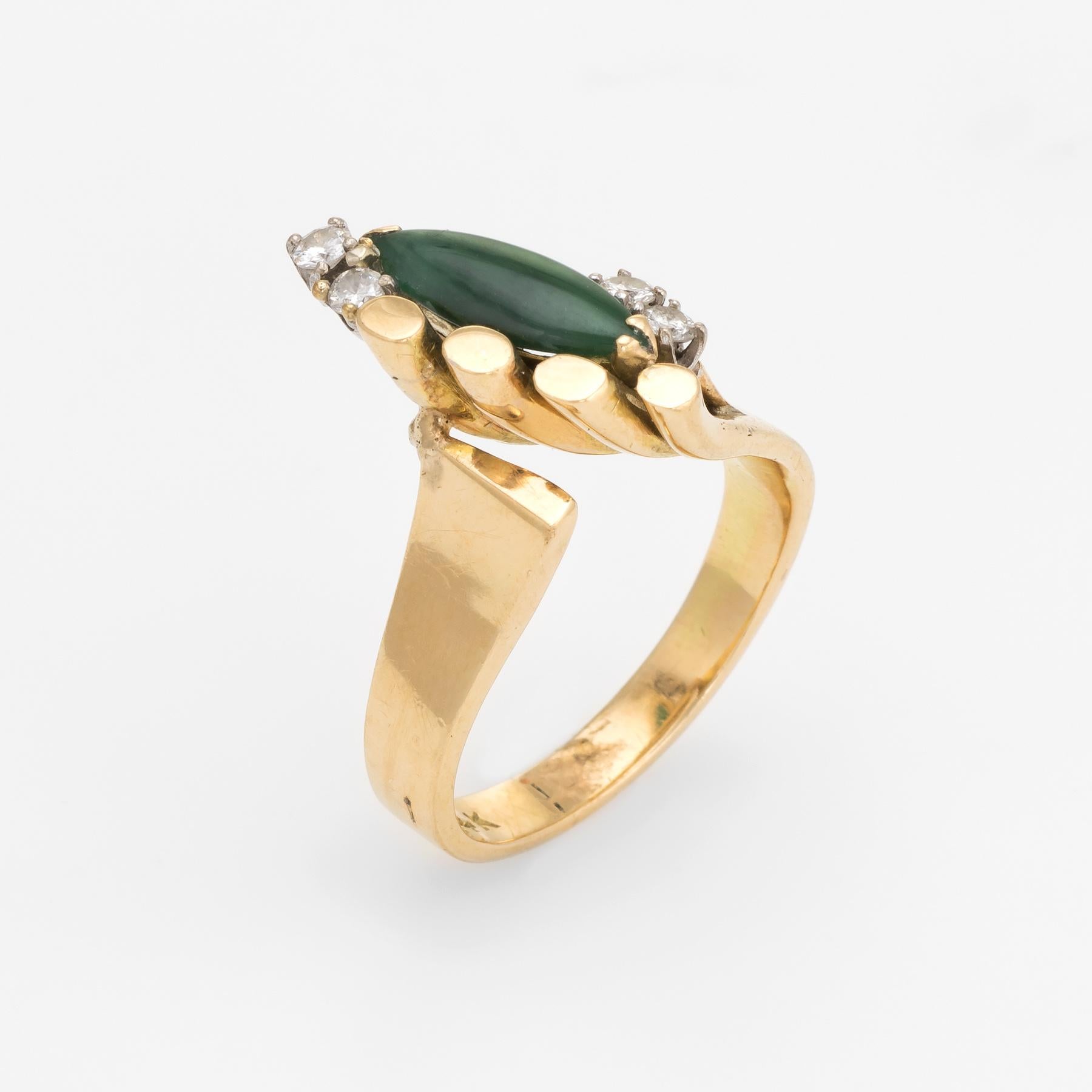 Finely detailed vintage jade & diamond cocktail ring (circa 1970s), crafted in 14 karat yellow gold. 

Centrally mounted marquise cut cabochon jade measures 13mm x 4mm (estimated at 1 carat), accented with four estimated 0.03 carat round brilliant