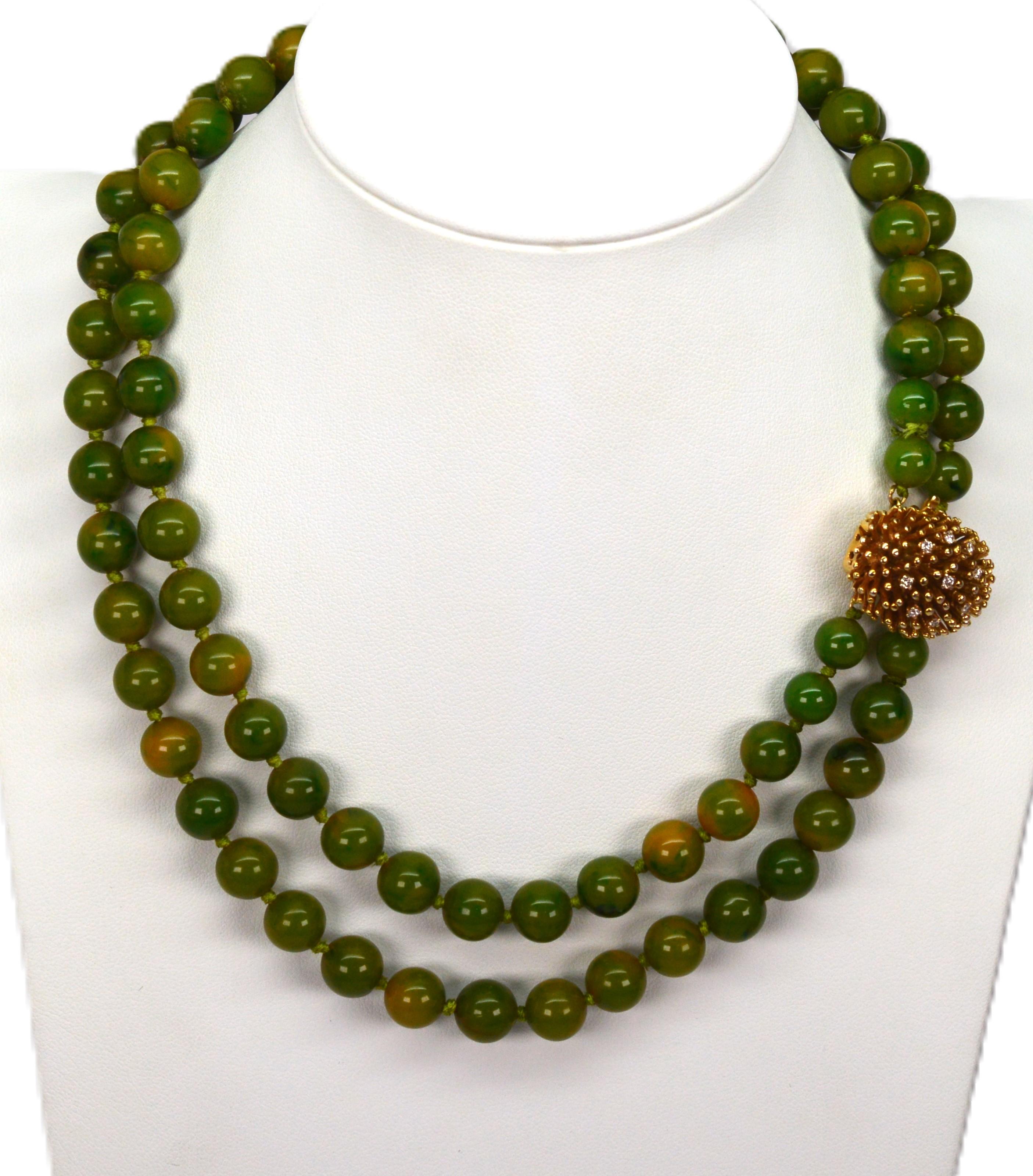 With a look of vintage color and elegant style, molted moss green jade beads create this lovely double strand beaded necklace dressed with an decorative oval-shaped porcupine clasp in 14 karat yellow gold accented with diamonds. The vibrant