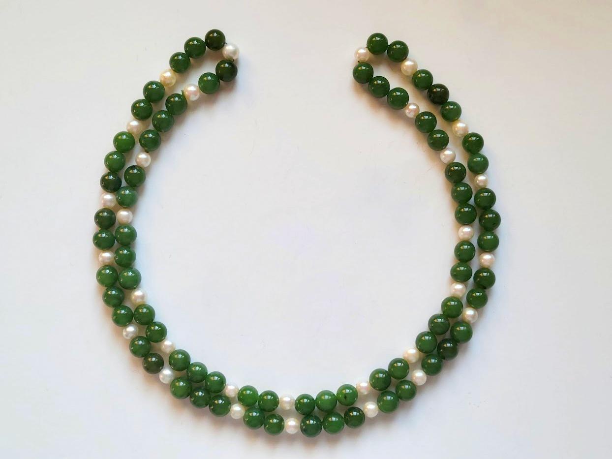 Introducing a classic necklace made of exquisite natural freshwater white pearls and premium quality natural green nephrite.

The length of the necklace is 30 inches (76 cm).
The size of the smooth round nephrite beads is 7.7-8 mm, and the size of