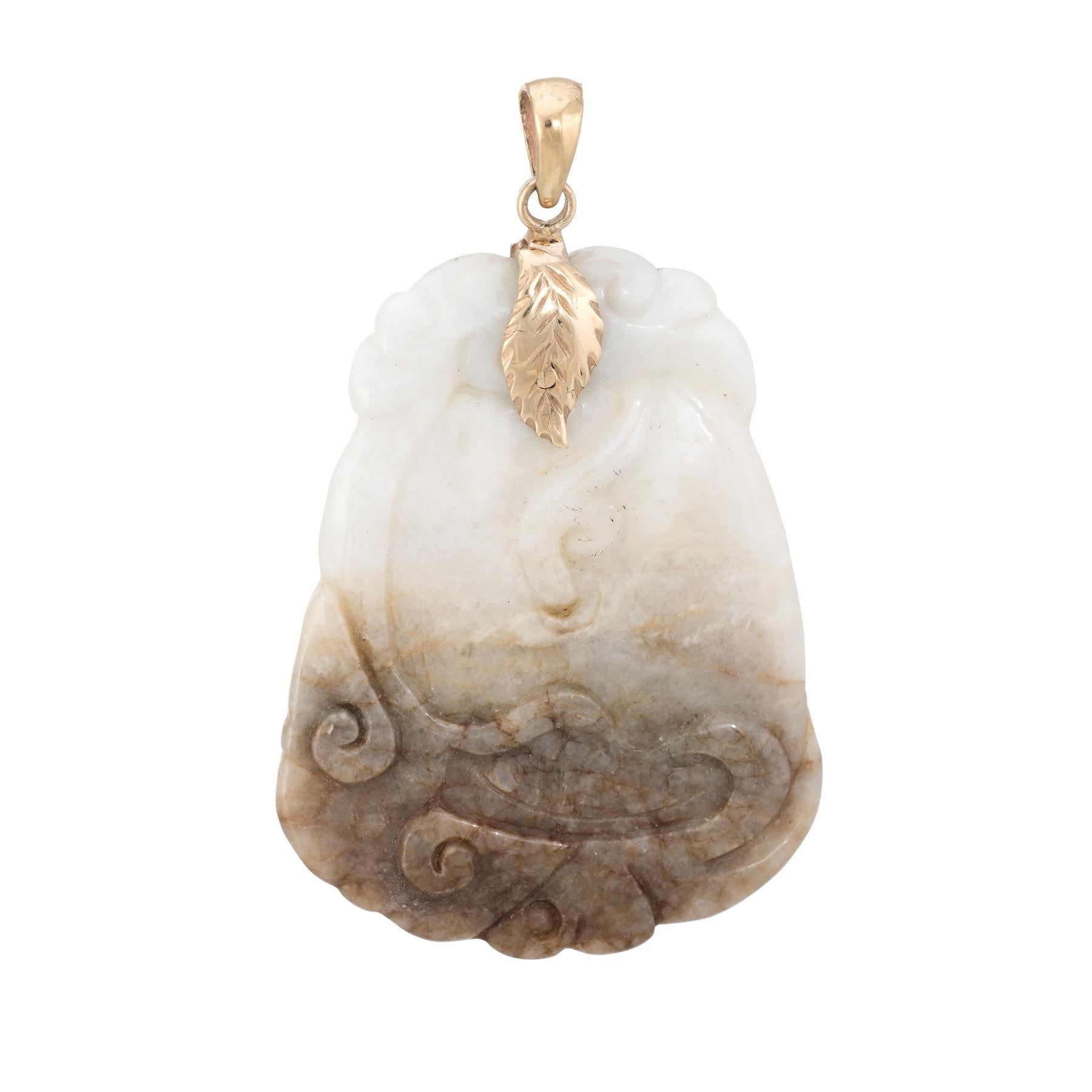 Finely detailed vintage jade pendant (circa 1960s to 1970s), finished with a 14 karat yellow gold bale. 

The jade measures 2 x 1 1/2 inches and is carved in a botanical motif. The jade graduates from white to a warm shade of brown at the base.