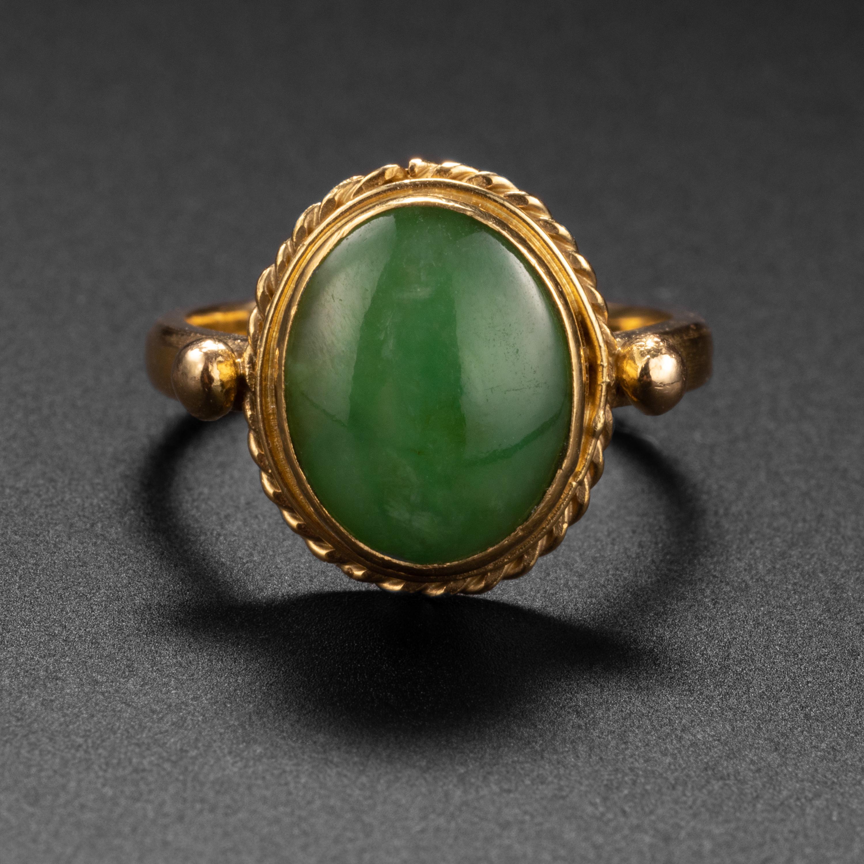 This vintage (circa 1980s) ring was hand-crafted in luxurious 22K pure gold that has been bezel-set with a luscious apple-green cabochon of natural, untreated jadeite jade. The jade measures 10.01 x 8.2mm and is highly translucent, despite the