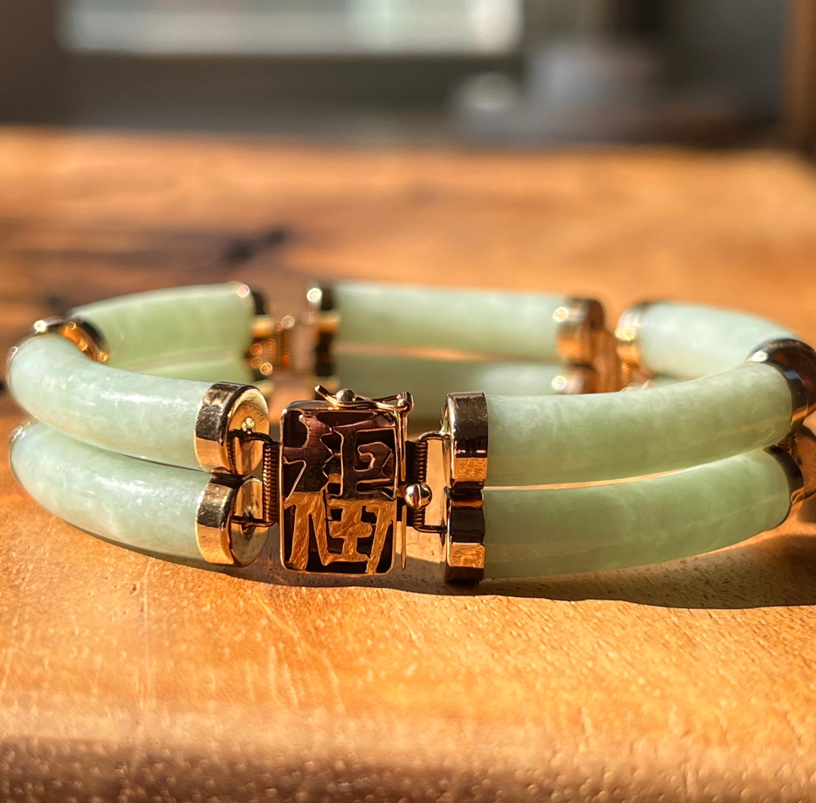 Dieses zweireihige Armband aus 14-karätigem Gelbgold mit zehn röhrenförmigen Gliedern aus natürlichem Jadeit, die jeweils ca. 26 x 6 mm groß sind, ist ein auffallendes Zeichen für raffinierte Eleganz. Der leuchtend grüne Jadeit wird durch die warme