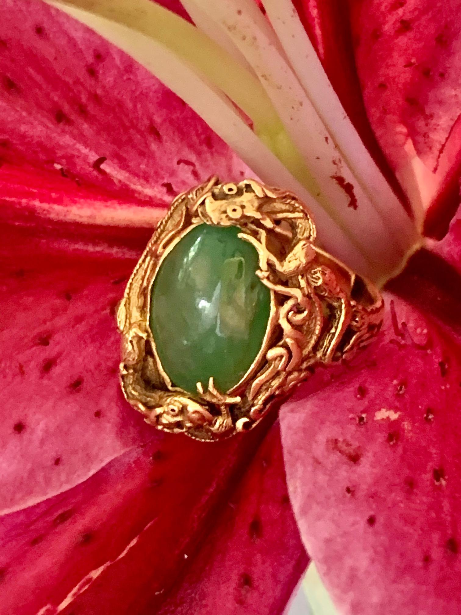 This vintage, dragon motif 22 kart yellow Gold ring, features a large, polished cabochon Jadeite stone.  The dragons are circling this beautiful stone.  
This ring is adjustable.
Stone Size: 14 x 10mm
Ring Size: 6
Weight: 10.1 grams