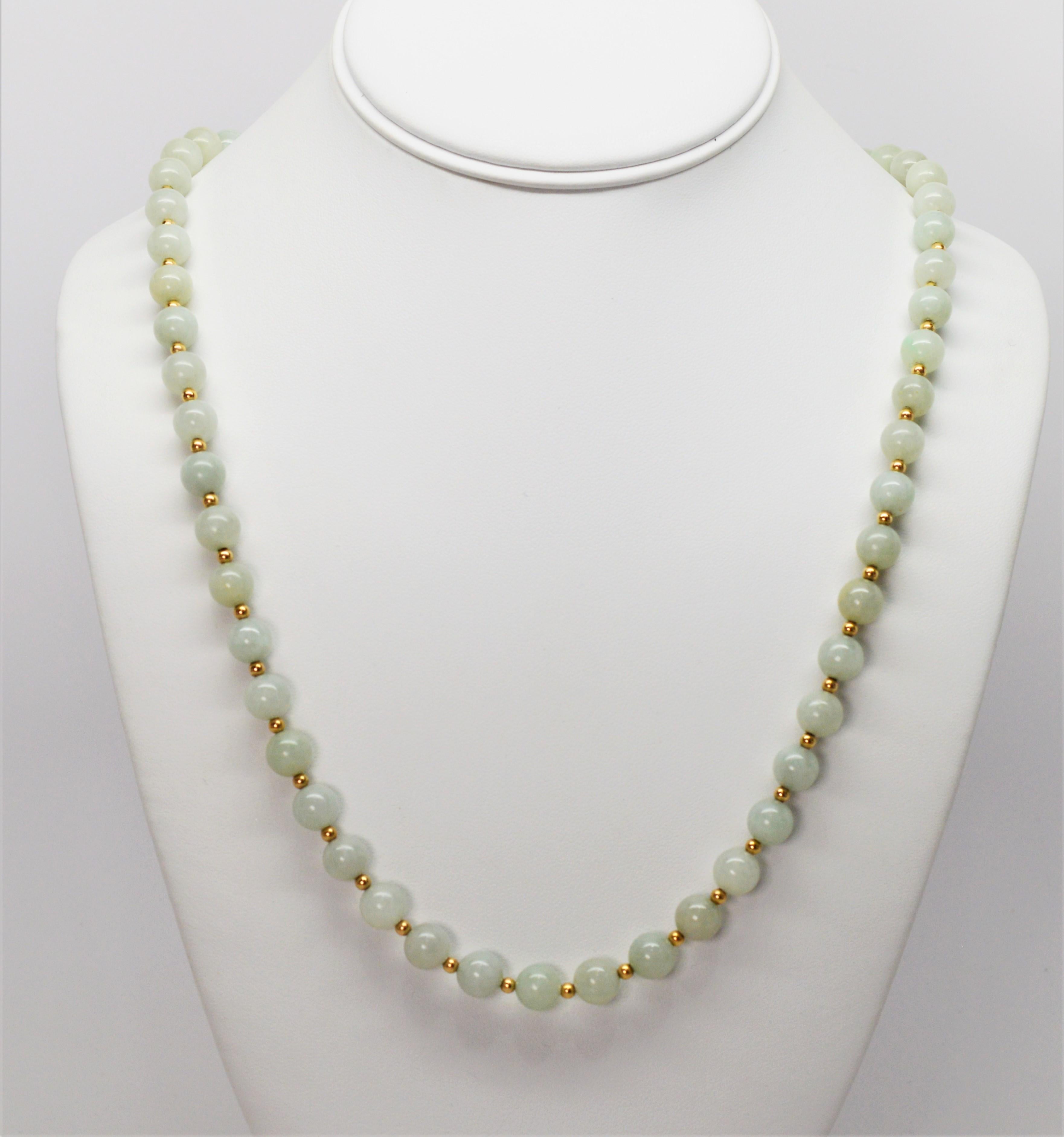 Serene, in a soft moss green shade, seventy one natural jadeite hand strung beads create this twenty eight inch necklace accented with tiny fourteen carat yellow gold beads that enhance the natural hues and veining of the  8 mm jadeite beads. In