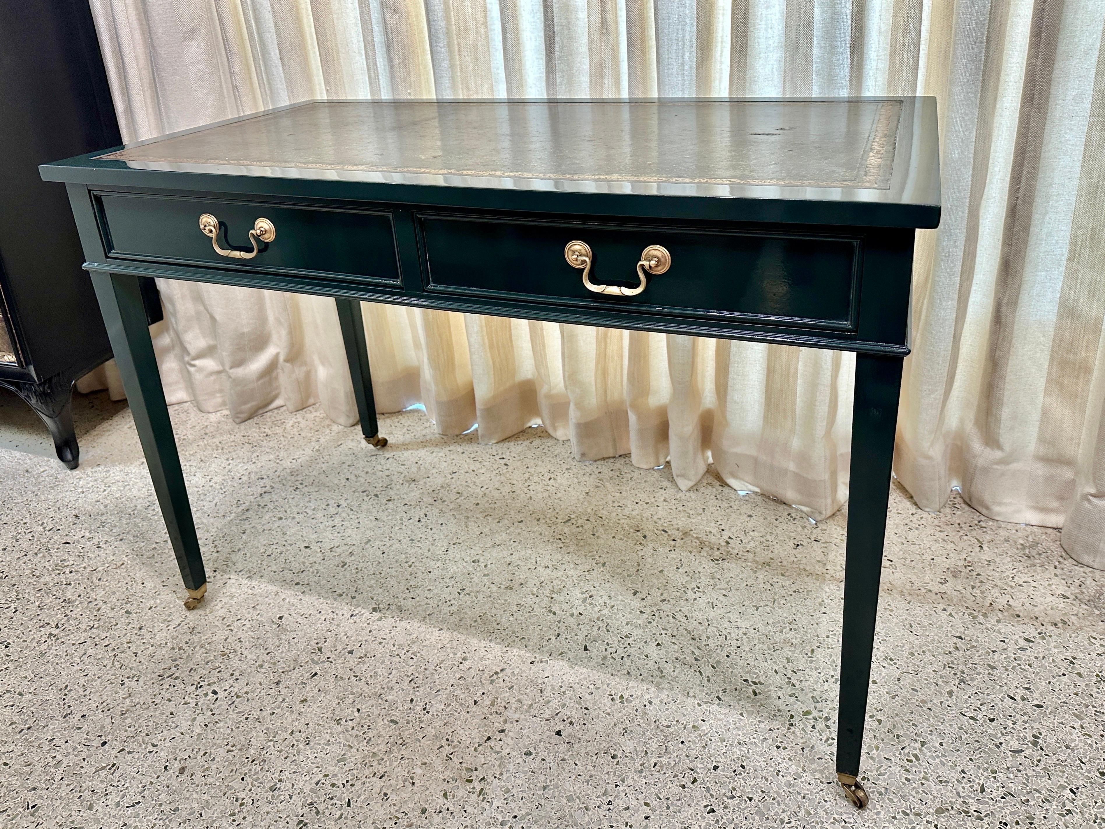 British Jaguar green lacquered Louis XVI style desk with original embossed leather top and two drawers.  This desk sits on brass casters.  Simply stunning and elegant.