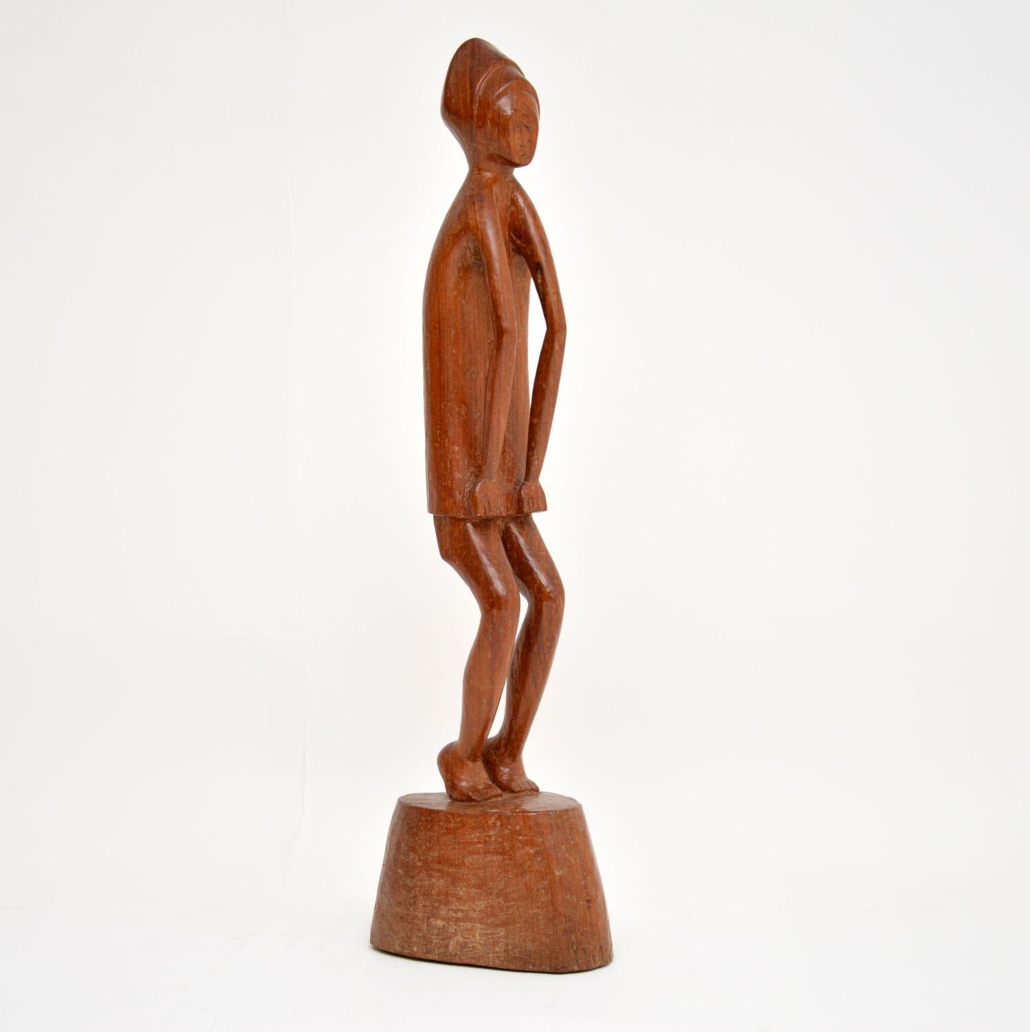 Una bellissima scultura vintage in legno intagliato, che sembra essere realizzata in noce o teak massiccio. È firmata in basso dall'artista K. Tekroade (per quanto ne sappiamo!), e ha anche un'etichetta con il nome e la provenienza dell'artista, la