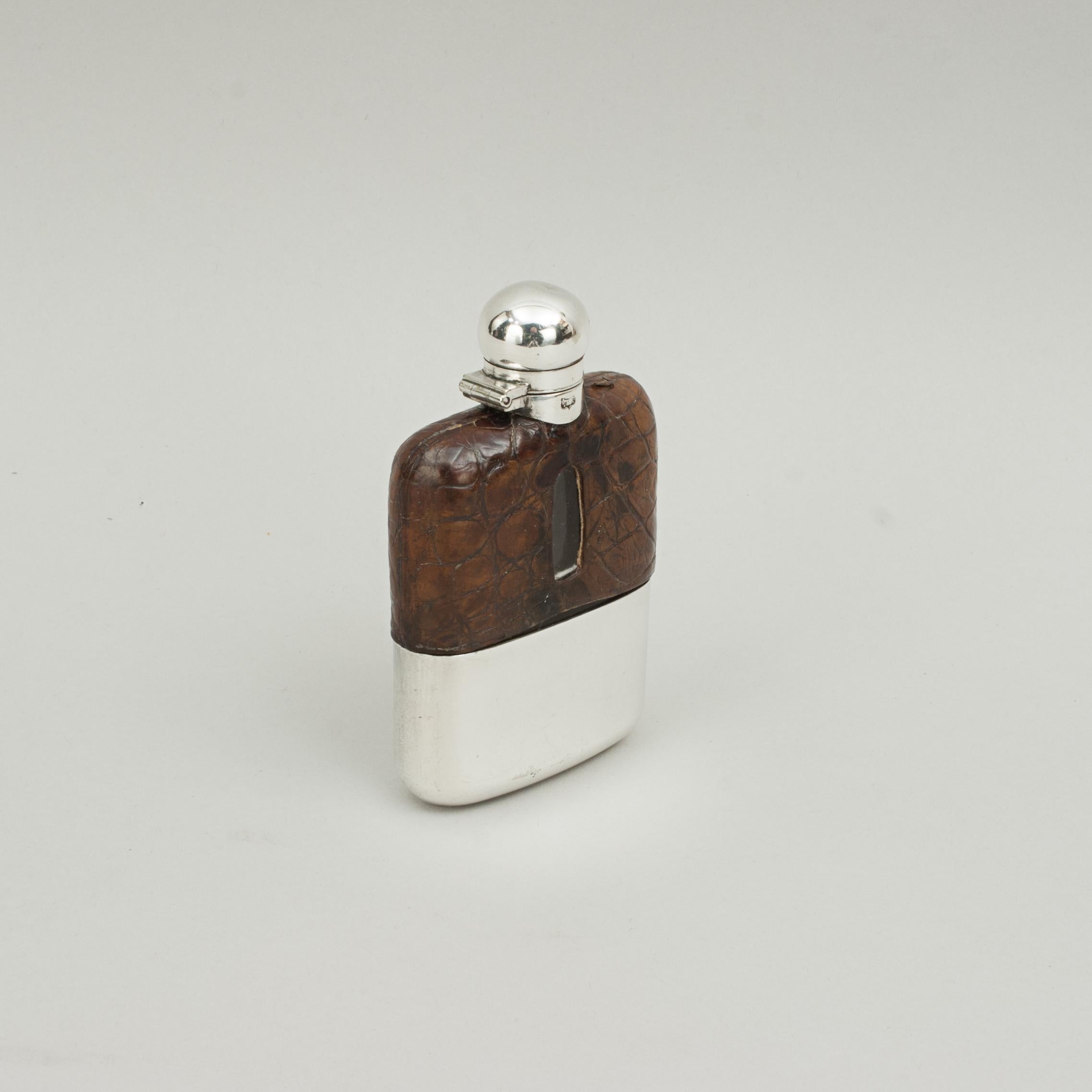 Gentleman's small silver plated hip flask By James Dixon.
A silver-plated spirit hip flask made by James Dixon & Sons, Sheffield. The pocket hip flask has a curved profile, the upper portion of the glass flask ornamented in leather (simulated
