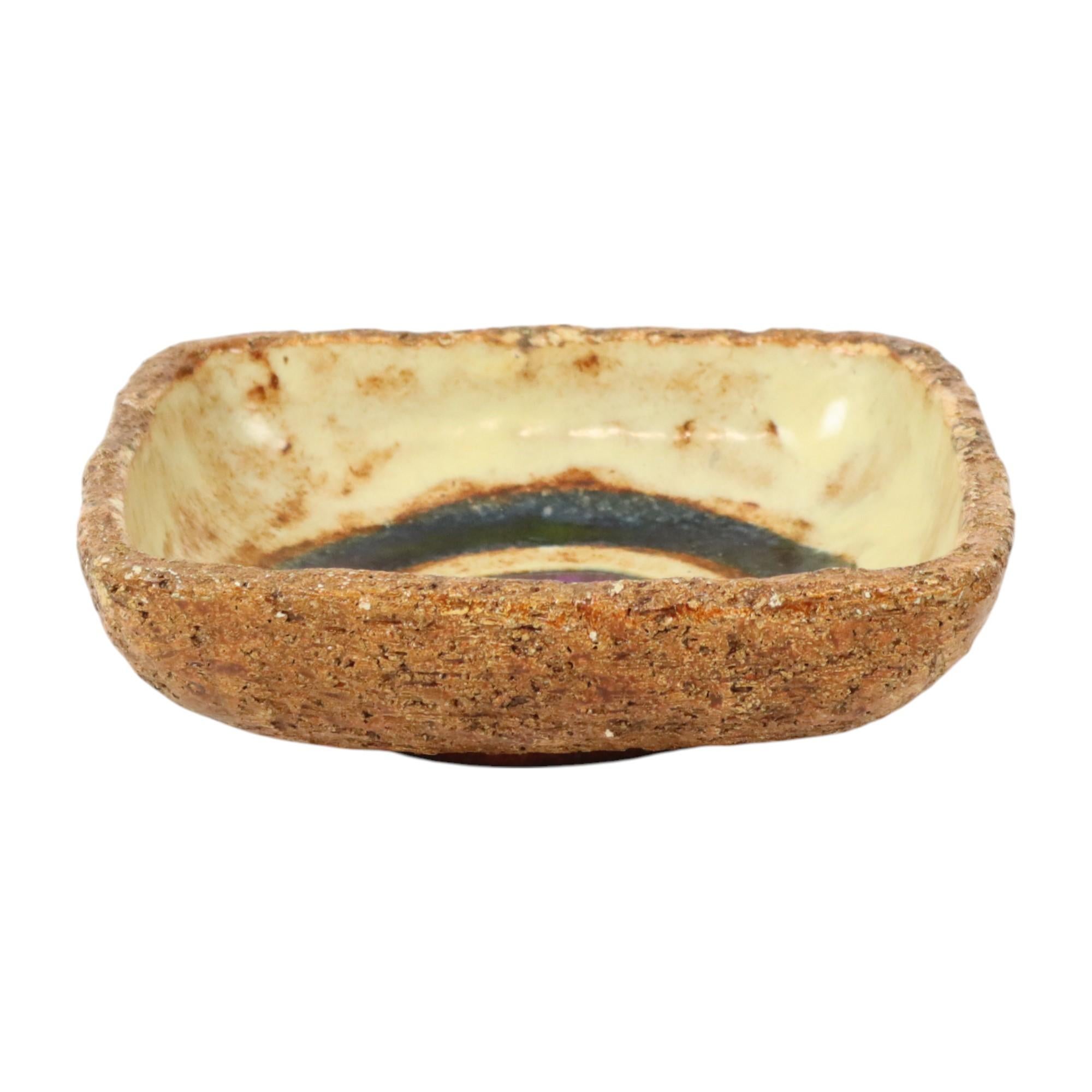 Precioso cuenco vintage cuadrado con un gran anillo azul y otro más pequeño morado en el centro y un fondo marrón estilo lava gorda, del famoso ceramista Jan Van Erp, de cerámica vidriada, Países Bajos, objeto de arte cerámico de los años 60.

En