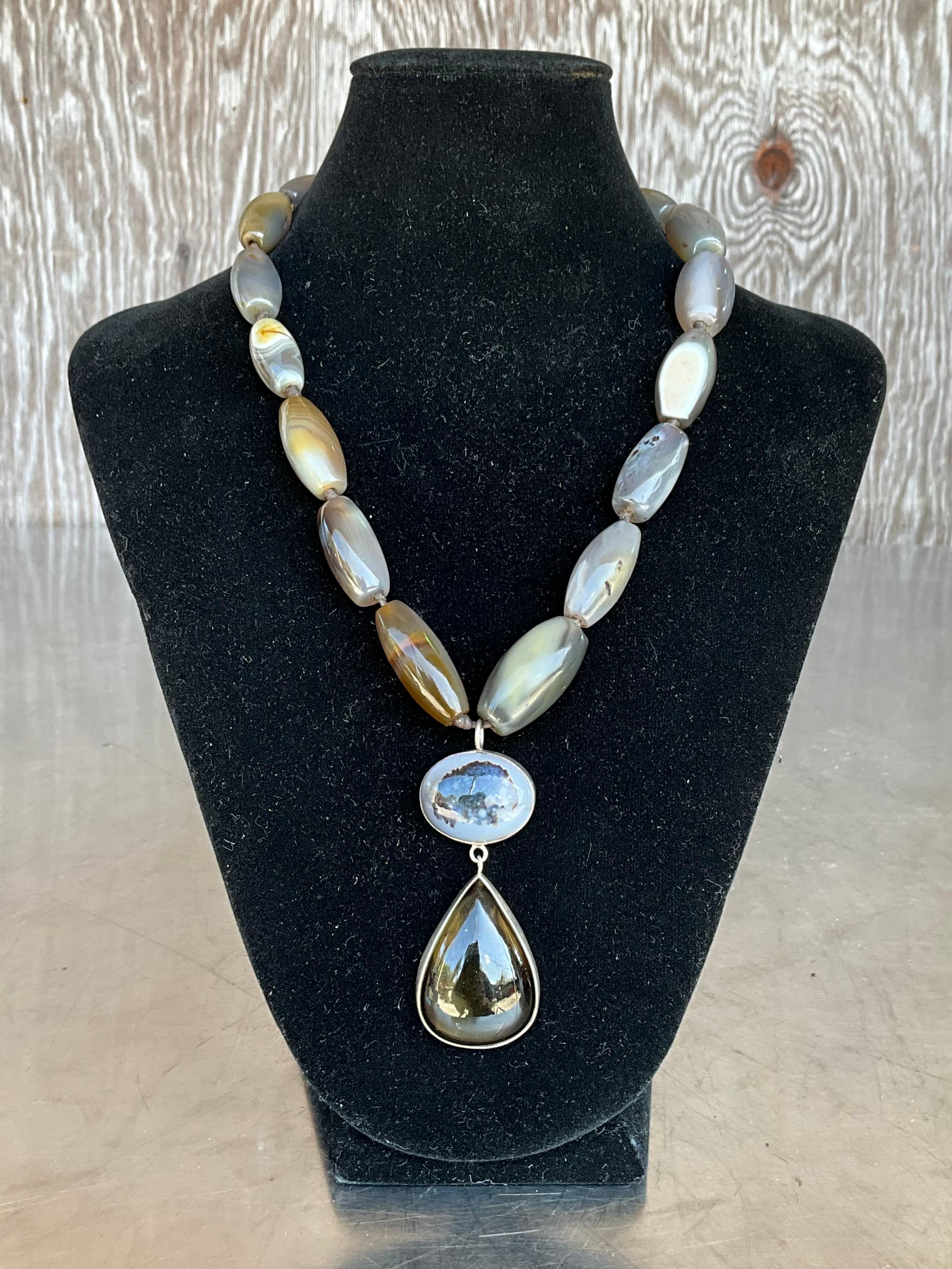 Le collane di Jane Diaz presentano spesso elementi artigianali come catene, ciondoli e charme, incorporando materiali come l'argento sterling e la placcatura in oro. I suoi modelli si ispirano ai suoi viaggi e al suo background di antropologa
