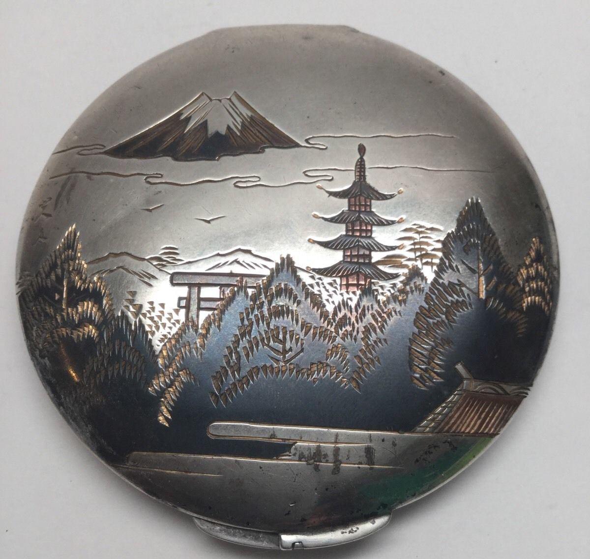 Vintage Japanese sterling silver powder compact. 
Two tone etched damascene of Mt. Fuji in Japan. 
Marked on bottom: MADE IN JAPAN, STERLING SILVER. 
Measures: 3 1/4