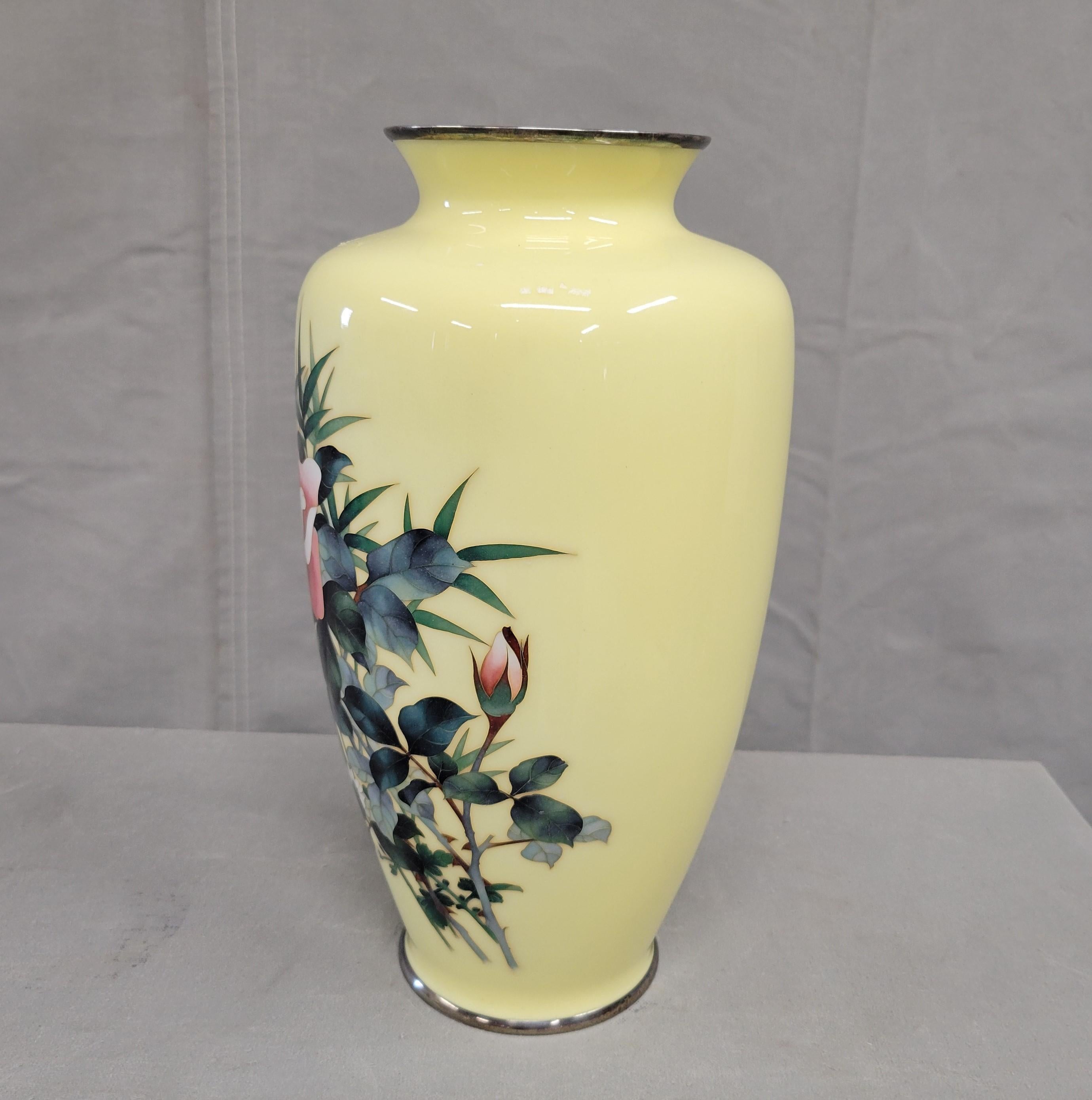 This large and rare antique vase was created by Japanese master artist Ando Jubei (1876-1956) during the Meiji period. The sterling silver body was covered with cloisonné enamel and decorated with roses in shades of butter yellow, forest green,