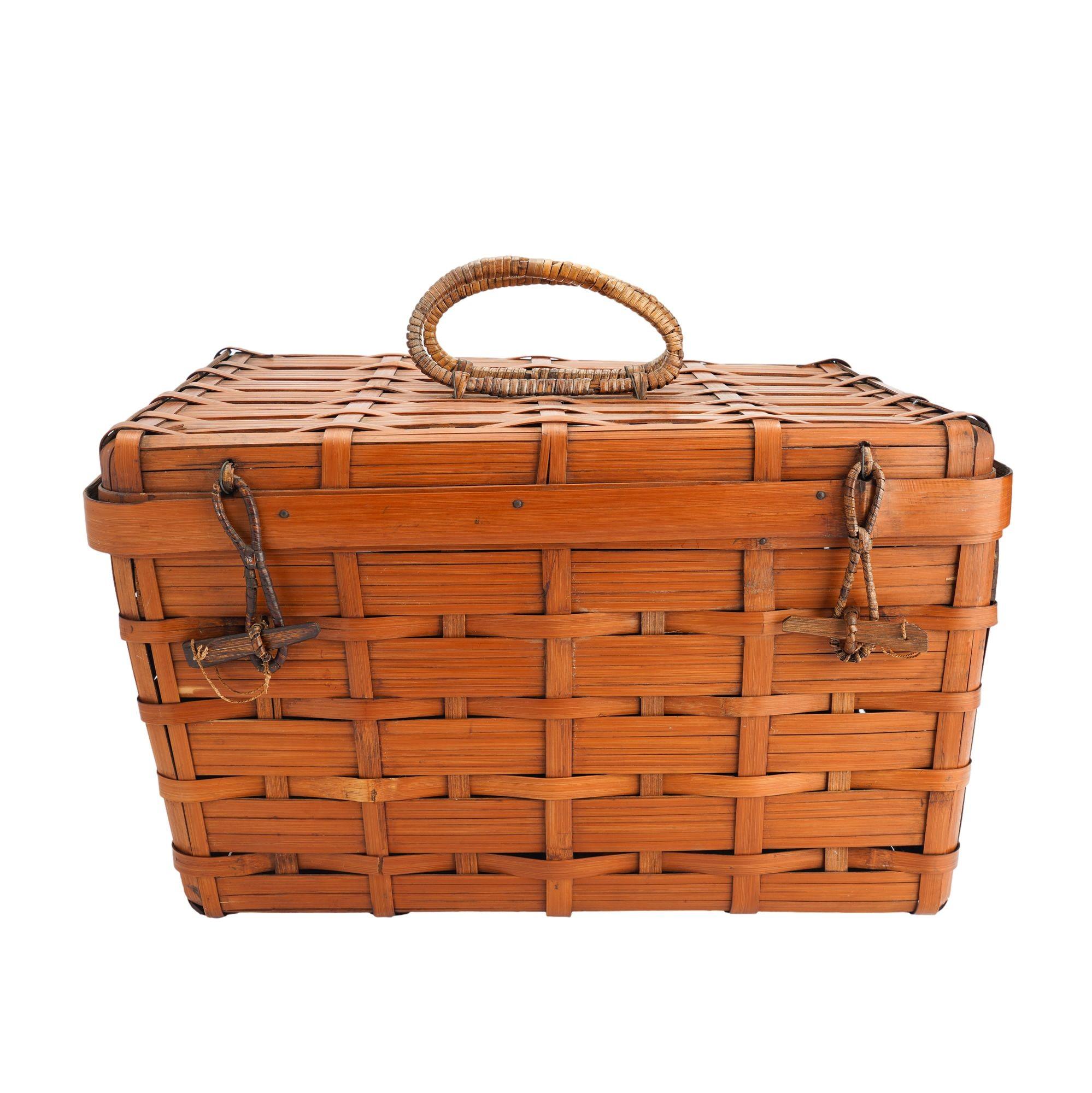 Vintage Japanese square bamboo picnic basket with brass hinged lid. The center of the lid is fitted with a pair of bamboo wrapped handles and the front edge is fitted with two bamboo wrapped toggle closures. The basket is woven of dyed bamboo stays