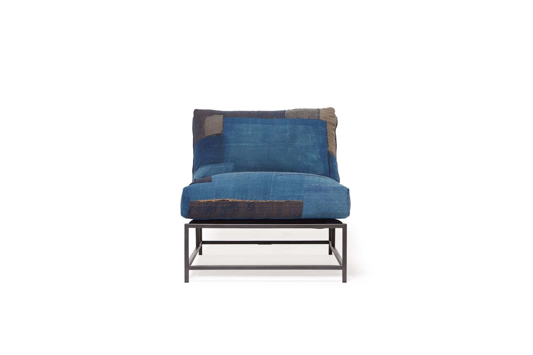 Der Inheritance Chair von Stephen Kenn ist ebenso bequem wie einzigartig. Das Design zeichnet sich durch eine exponierte Konstruktion aus, die aus drei Elementen besteht: einem Stahlrahmen, einer weichen Polsterung und stützenden Gurten. Der tiefe