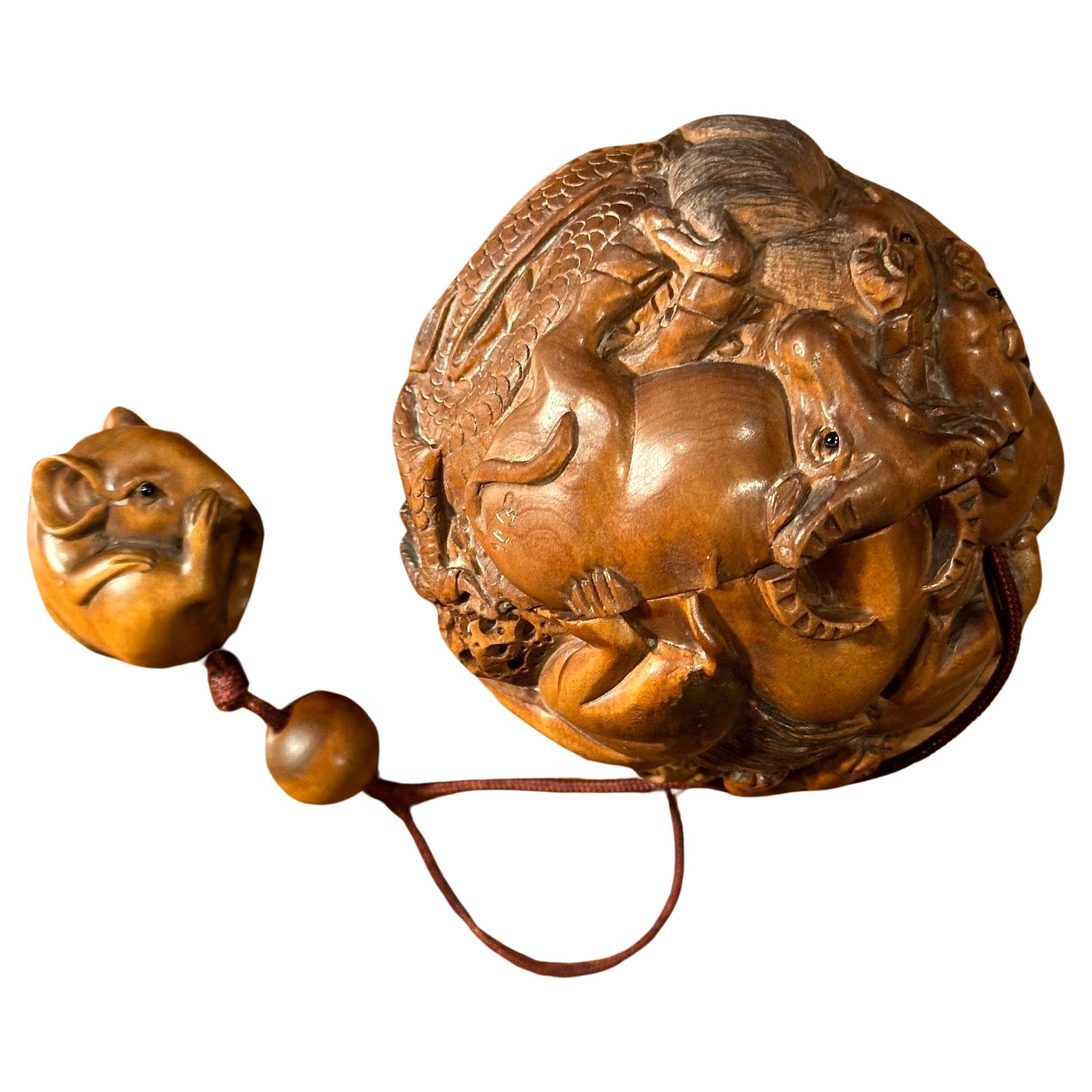 Bola inro y netsuke japonesa vintage de madera de boj con doce animales, por Kozuki, hacia la década de 1940.  La pieza está bien tallada, con maravillosos detalles y en muy buen estado vintage; incluye un pequeño netsuke de bola de rata.  La pieza