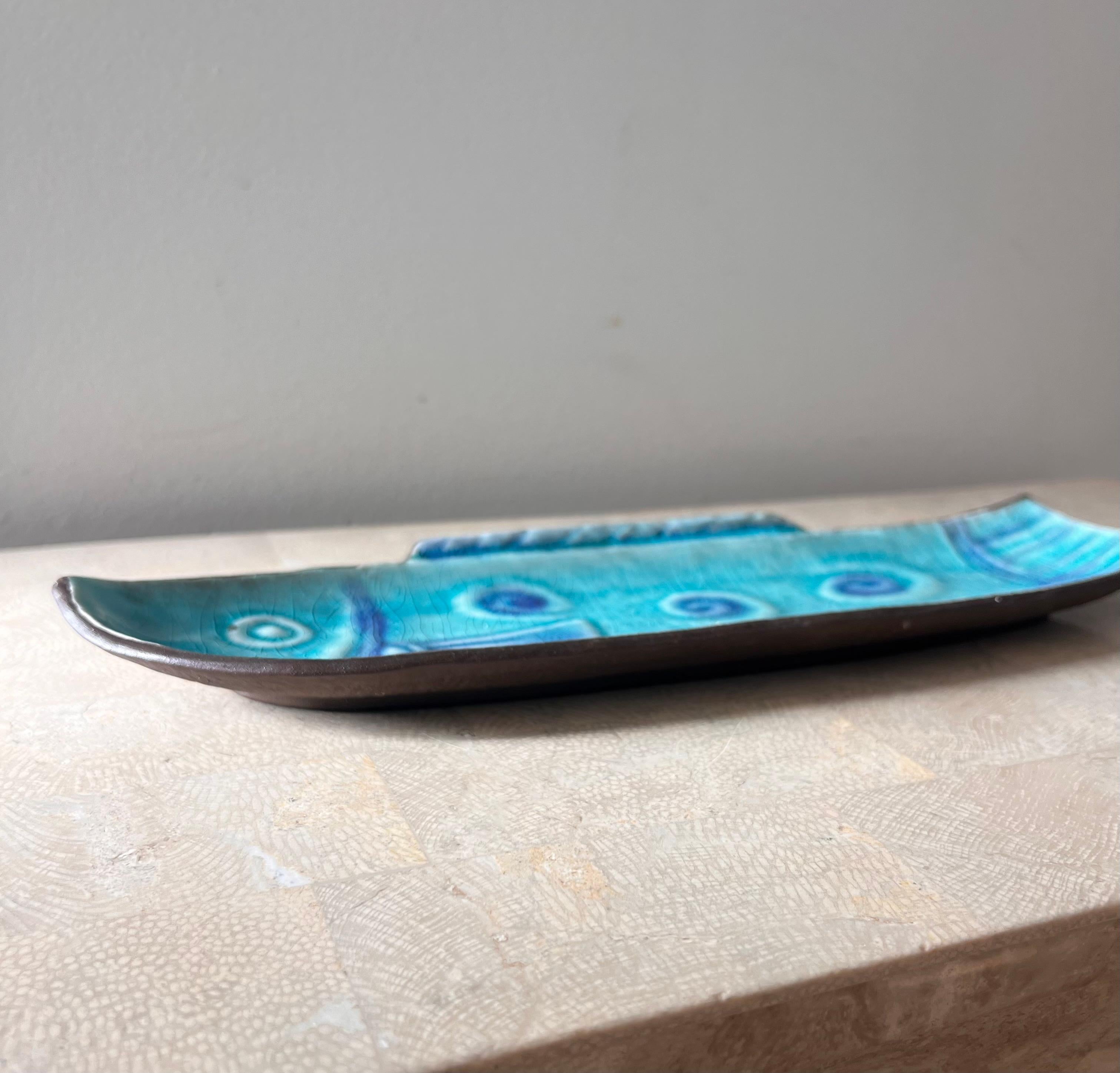 A vintage Japanese glazed ceramic fish platter, circa late 1960s. Tones of Yves Klein and swimming pool blues. The “crackle” ceramic technique shines here. Few signs of age. Pick up in central west Los Angeles or we ship worldwide. 
13.5” W x 4” D x