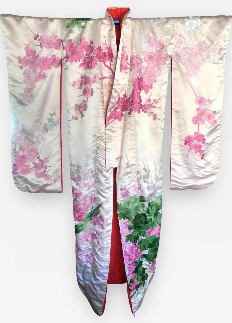 A very elegant Japanese ceremonial kimono, circa 1930s in an oriental Art Deco style. A blush white-pink satin silk background with elaborate and intricate embroidery in deep green and bright pink. The front and the back of the kimono depict