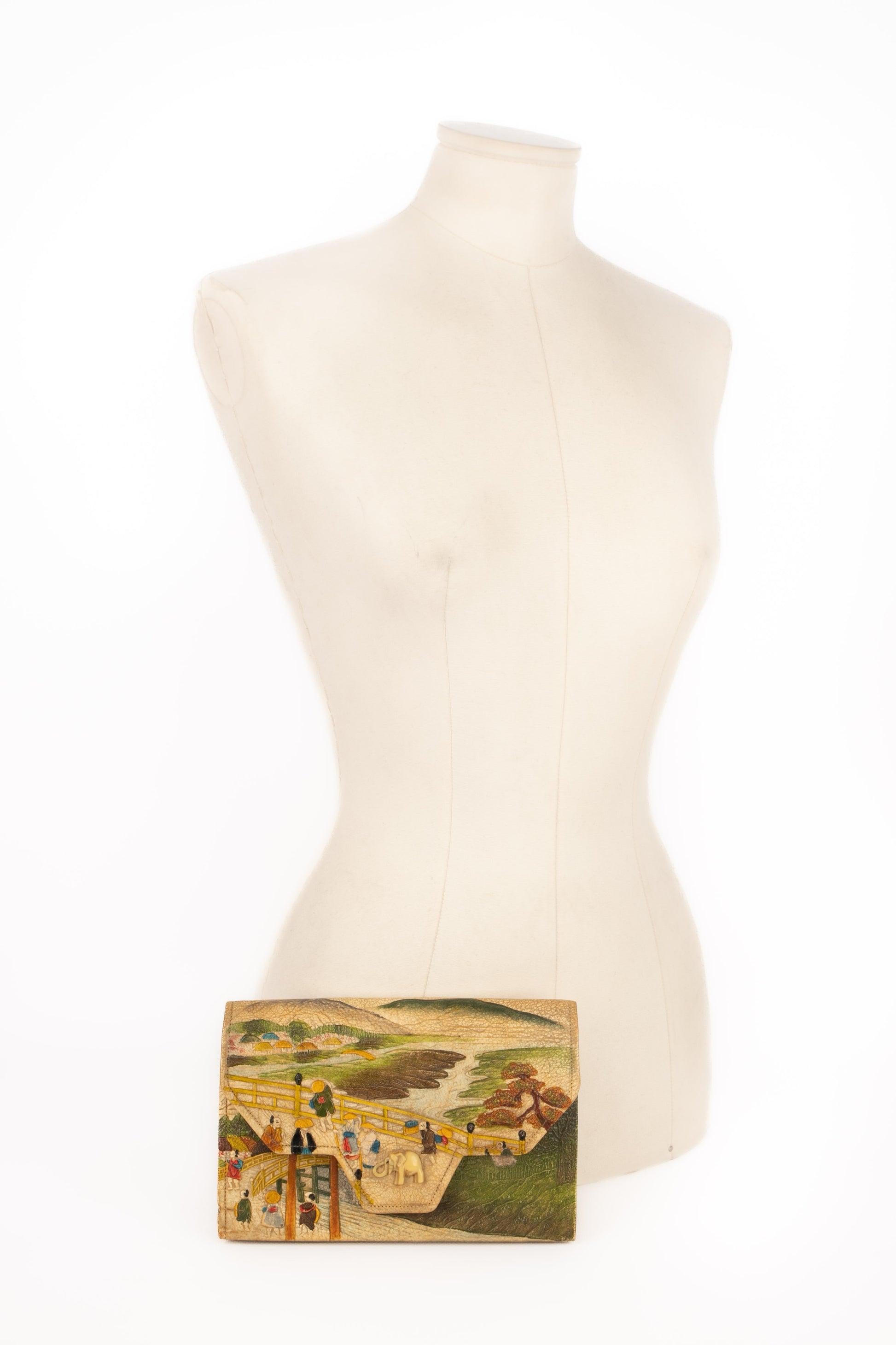 Unknown - Leather bag with hand-painting and relief, with a bone fastener representing an elephant, a silk interior, and a tiny mirror. Piece made in Japan from the 1920s/1930s. To be mentioned, the inside is worn.

Additional
