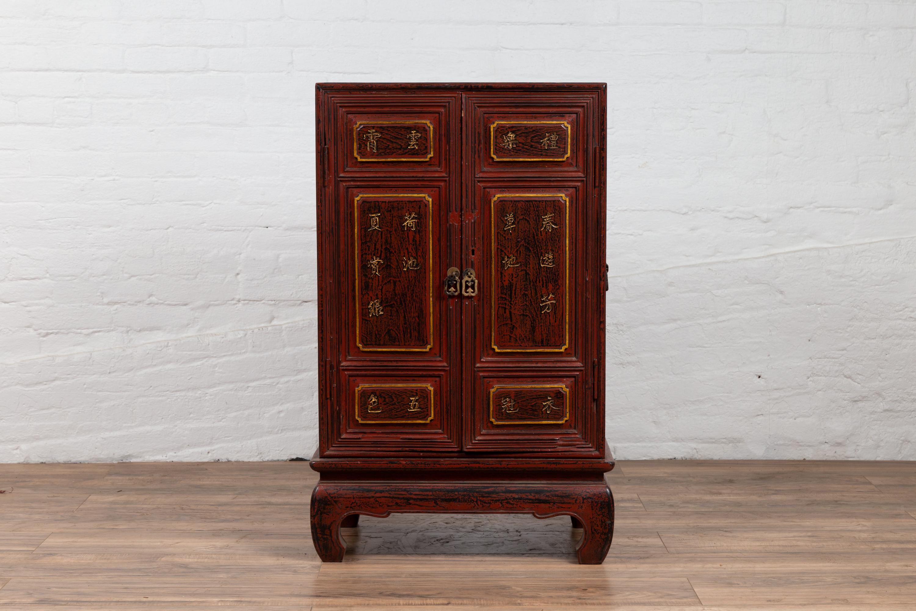 A Japanese vintage small display cabinet from the mid-20th century, with negora lacquer and gilded calligraphy. Born in Japan during the mid-century period, this lovely display cabinet features two doors, adorned with raised panels showcasing gilded