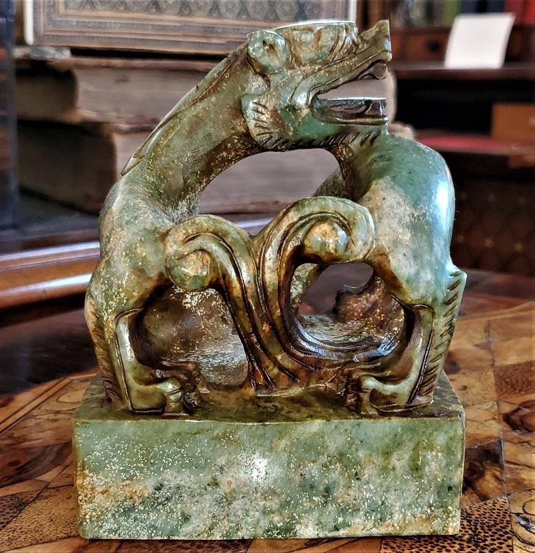 Presenting a stunning and rare vintage Chinese green and brown serpentine foo dog chop seal,

Hong Kong/Chinese, circa 1950s or 1960s

A fantastically carved foo dog in a contorted form, hand carved from a single piece of mottled green, brown and