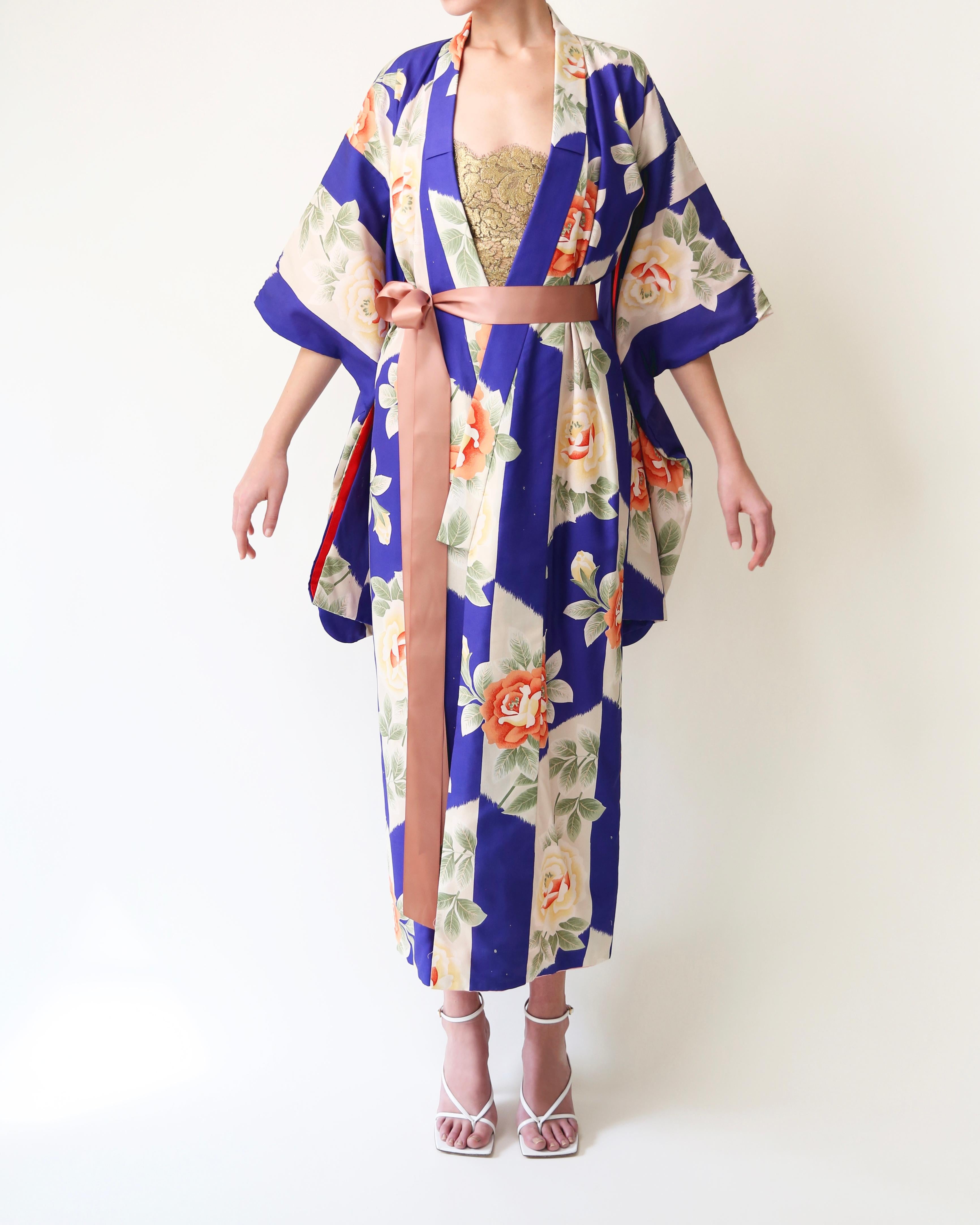 LOVE LALI VINTAGE 

Vintage Japanese kimono
Handmade in Japan 
Floor length
Bright blue with beautiful orange and red rose print
Comes with a blush pink silk ribbon that gives you the option to wear this open or closed 
Lined in red and and pale