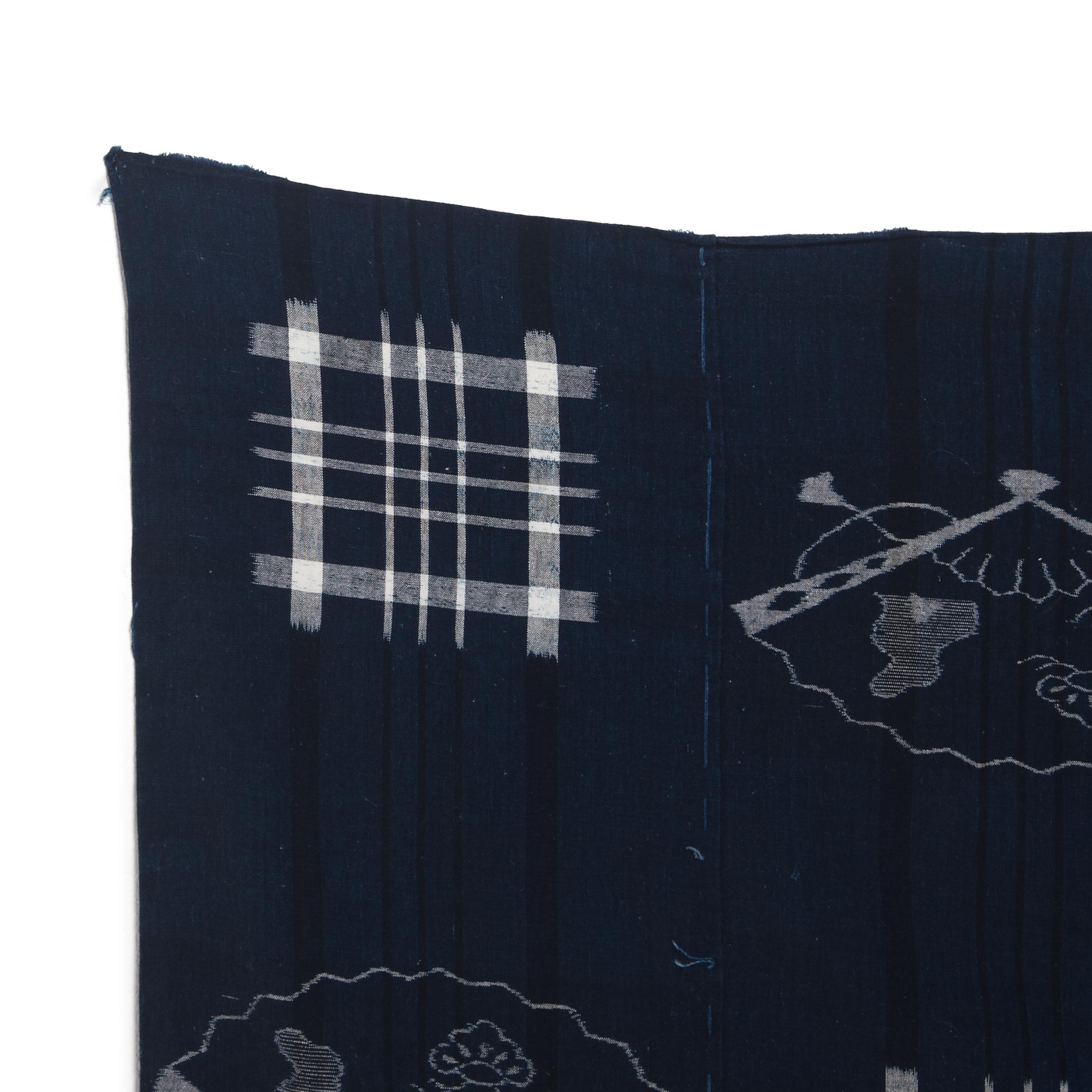 This vintage Japanese textile dates to the mid-20th century and has a strip woven design of alternating square check patterns and delicate fans, symbols of the journey of life. The textile is woven with a technique known as kon-kasuri, a form of