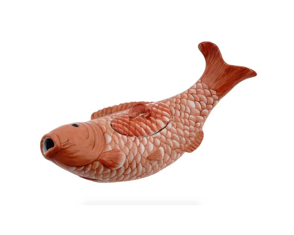A vintage Japanese fish tureen with a cover. Shaped like a majestic koi fish. The sinuous curves, delicately scaled body, and expressive facial features are rendered with precision and finesse. Marked underneath. Circa the mid 20th century. The koi