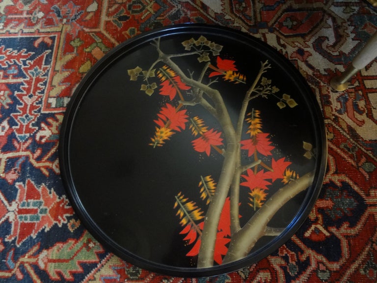 Extra large vintage Japanese lacquer tray. This stunning 24 inch round Japanese black lacquered tray has beautiful orange and yellow floral blossoms. Our lovely chinoiserie lacquer tray is perfect as a cocktail table accessory or displayed on an