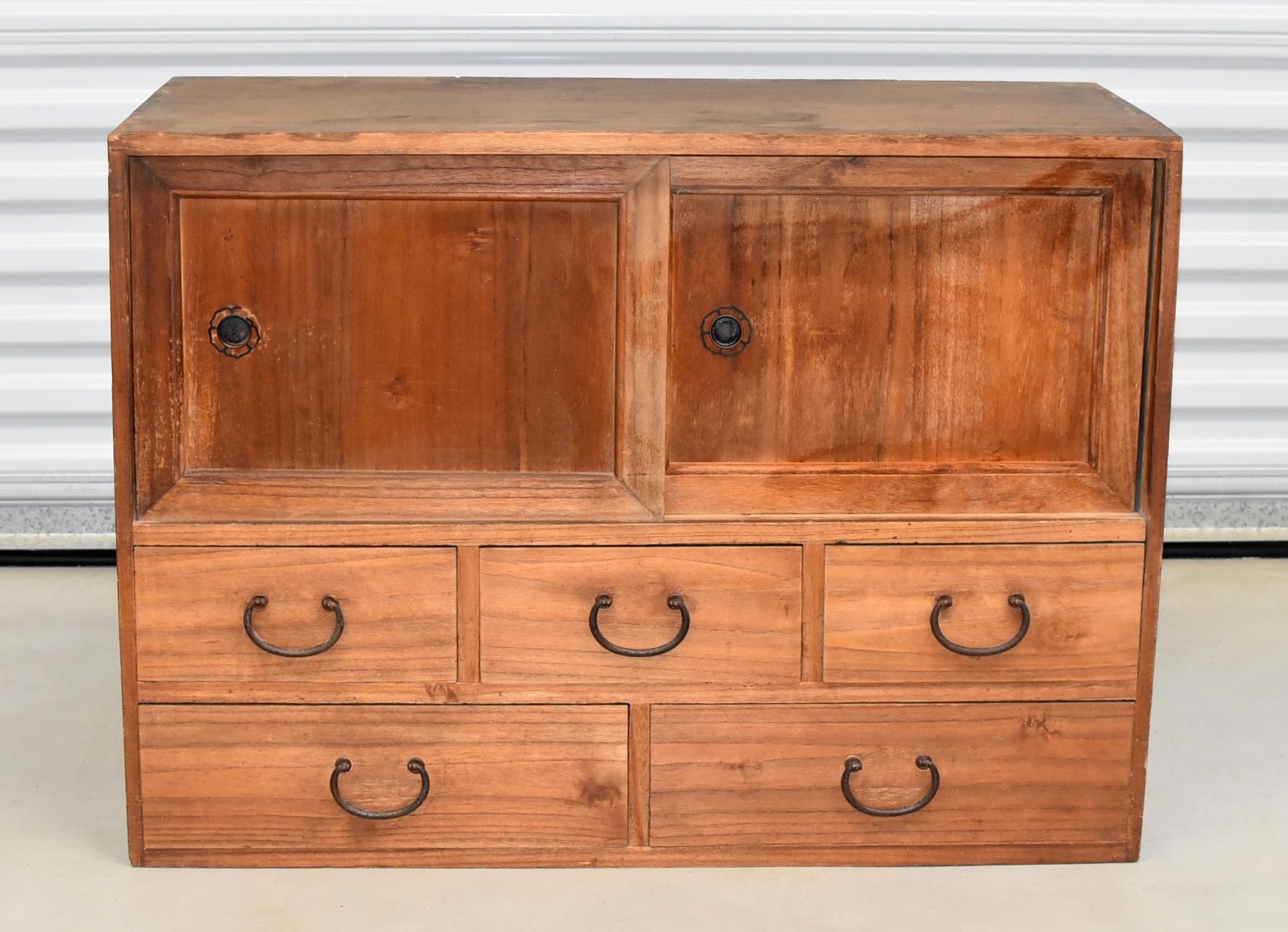 A beautiful vintage, Meiji period, Japanese low Tansu with a large compartment and five full capacity drawers. Unique, hand crafted solid iron hardware include daisy patterned door sliders and elegant classic drawer pulls. A very versatile piece.