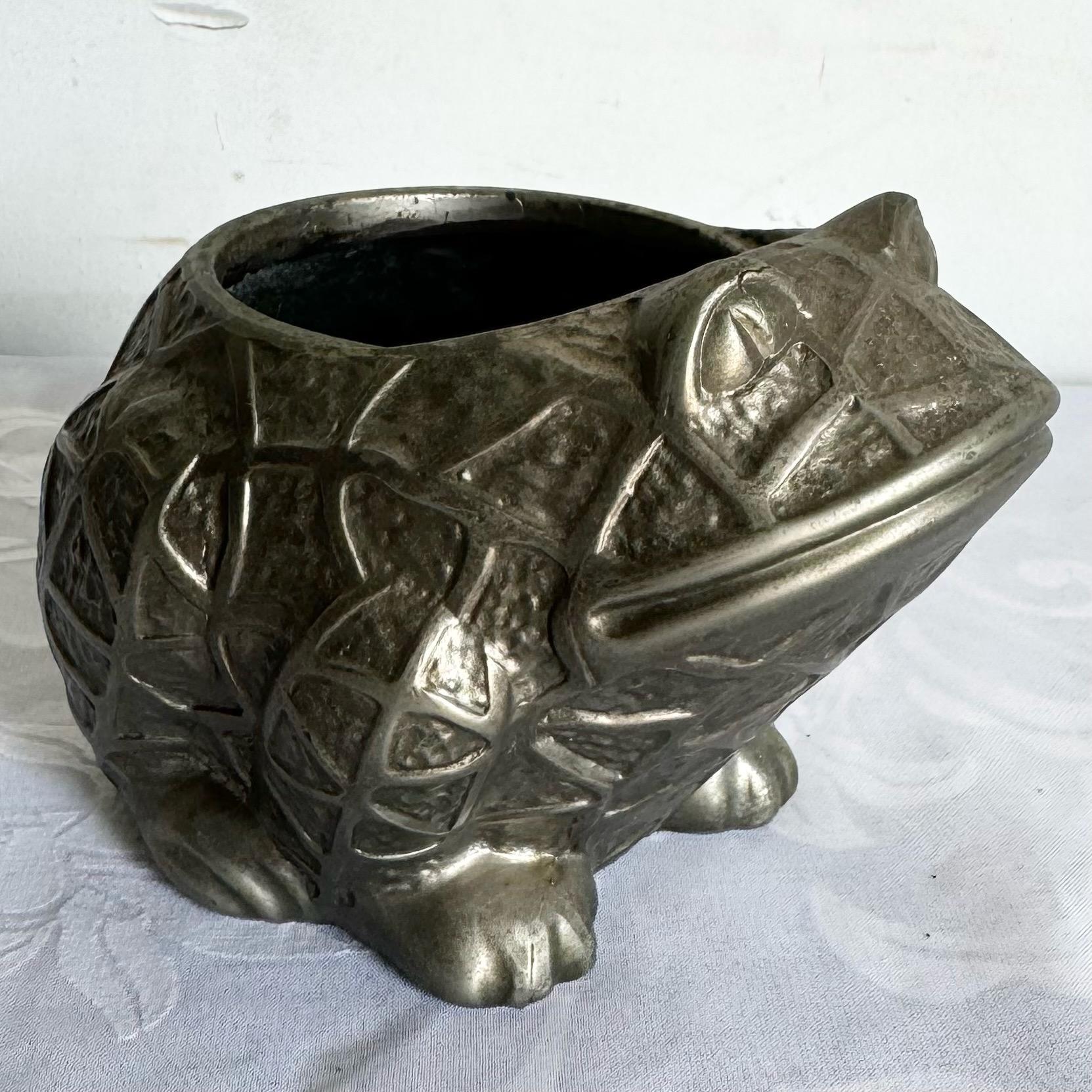 This vintage Japanese frog planter adds a whimsical touch to your decor with its charming, detailed metalwork. Perfect as a vase or planter, it brings both functionality and character, making it a unique statement piece for any indoor or outdoor