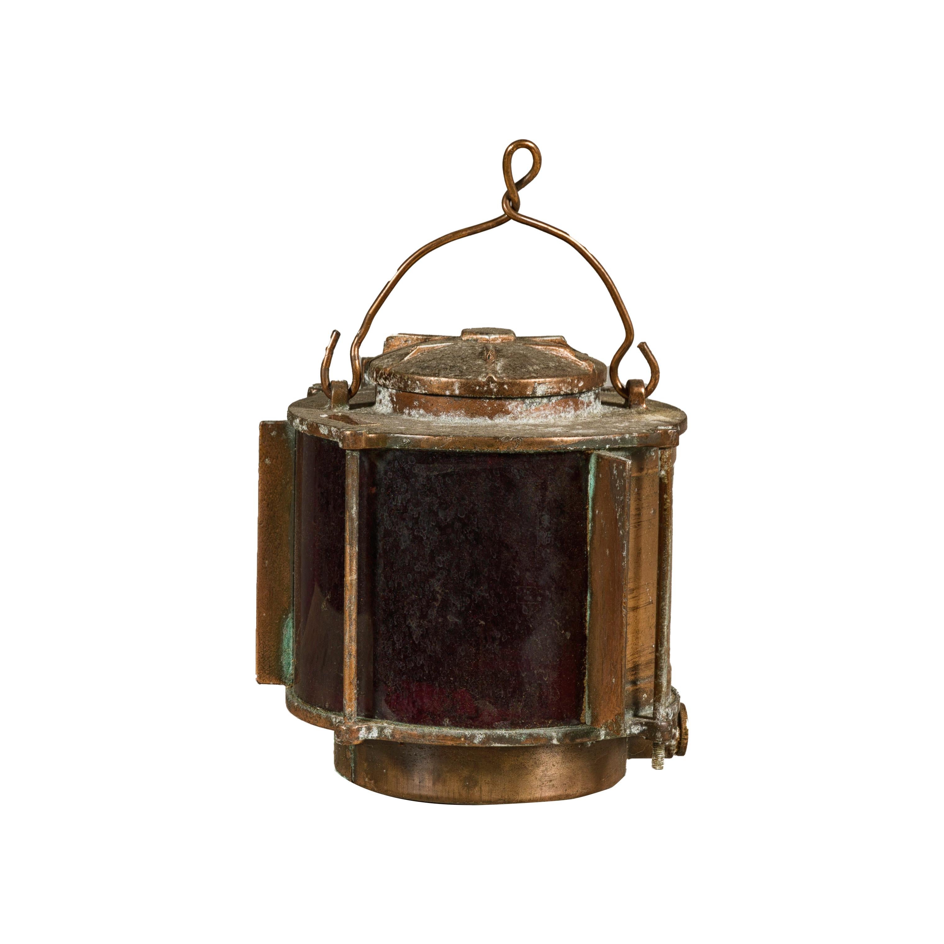 A vintage Japanese metal stern light ship lantern from the mid 20th century with handle and glass panels, inwired. This vintage Japanese stern light ship lantern, originating from the mid-20th century, embodies the robust spirit of maritime history.