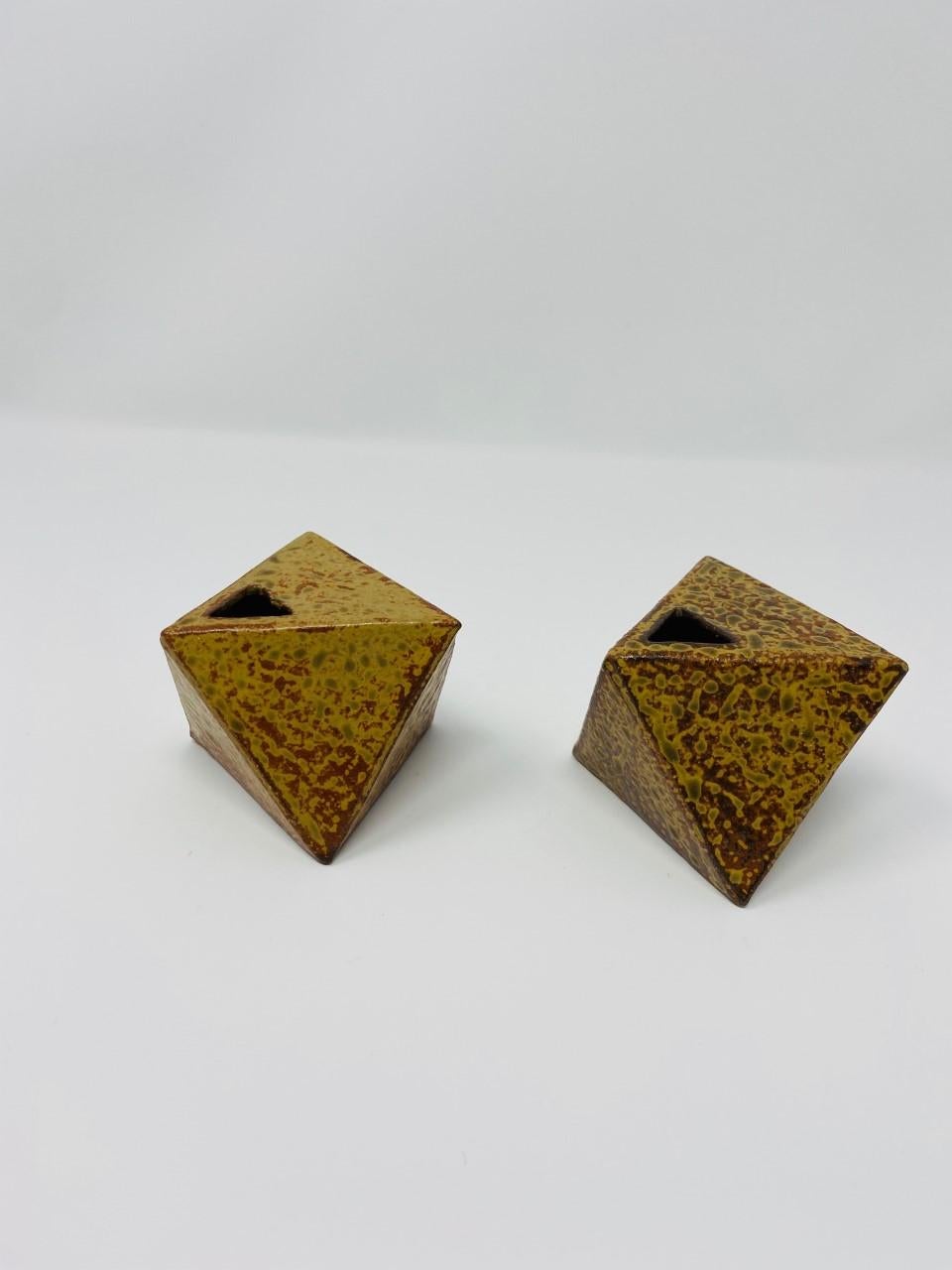 Alluring pair of Japanese hexagon ceramic bud vases/vessels. Modernist and striking, these ceramic pieces present an organic patina and texture which complements its sharp lines. Beautiful paired together or on their own. These pieces are unsigned.