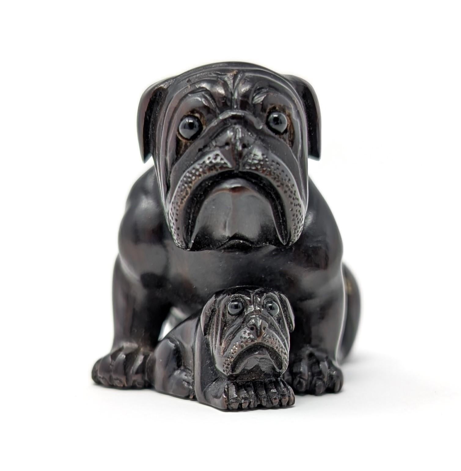 Finely crafted vintage hand carved wood netsuke figure. Beautifully detailed featuring a scene with a bulldog and its child, signed on the side of the figurine. Measures 1.8 inches in width by 1.4 inches in height.
