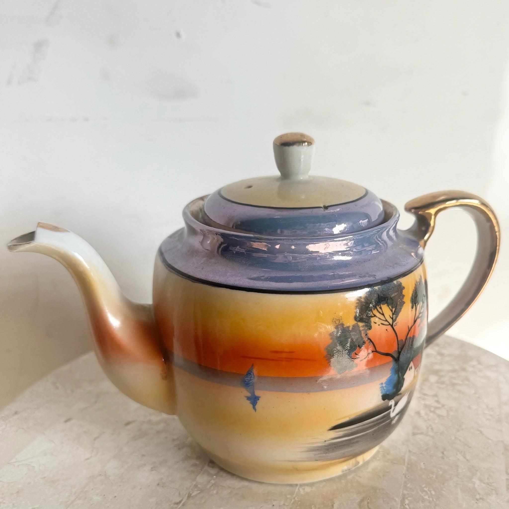 Tetera japonesa vintage de reflejo metálico con acabado iridiscente y detalles florales pintados a mano, perfecta para servir el té o exponer objetos de colección.
 
 Vendemos artículos tal y como se adquieren, sin restaurar ni reparar. Las piezas