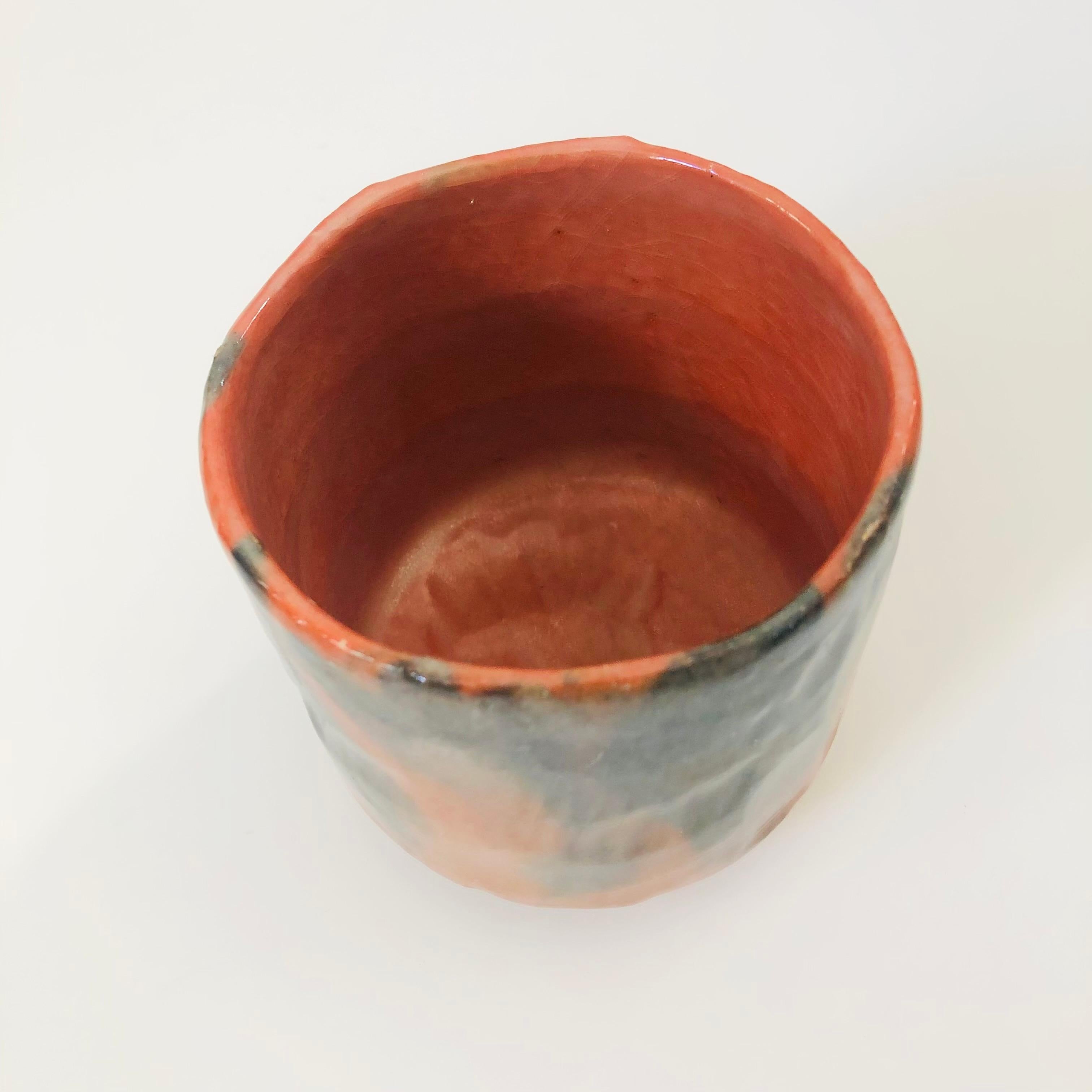 A vintage Japanese red raku pottery vase or bowl. Beautiful variation to the wood fired glaze that ranges from natural terra cotta to black. Lovely organic shape. Perfect for using as a bowl or planter. Stamped on the base by the maker.

