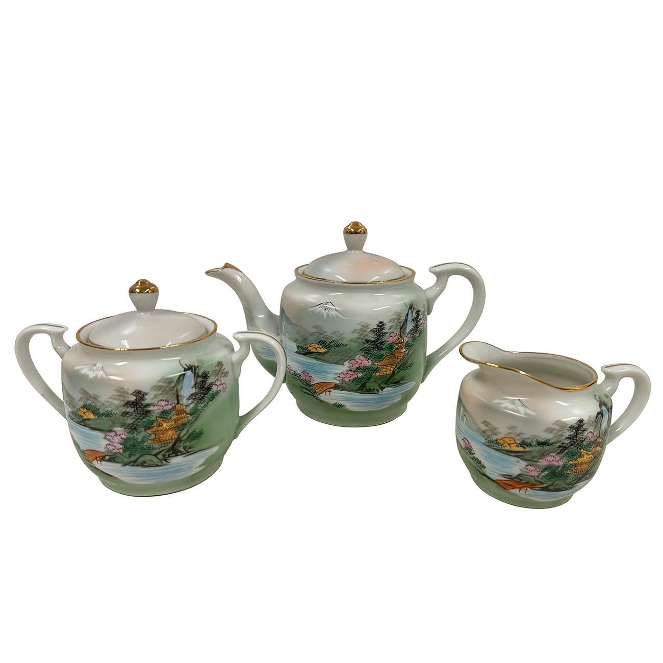 This bone china/Eggshell china tea set, produced in Japan between 1940-1950 in Japan, shows a beautiful architecture and landscape design. Hand painted with gilt plated rings on each tea cup. The delicate craftsmanship of these pieces exemplifies