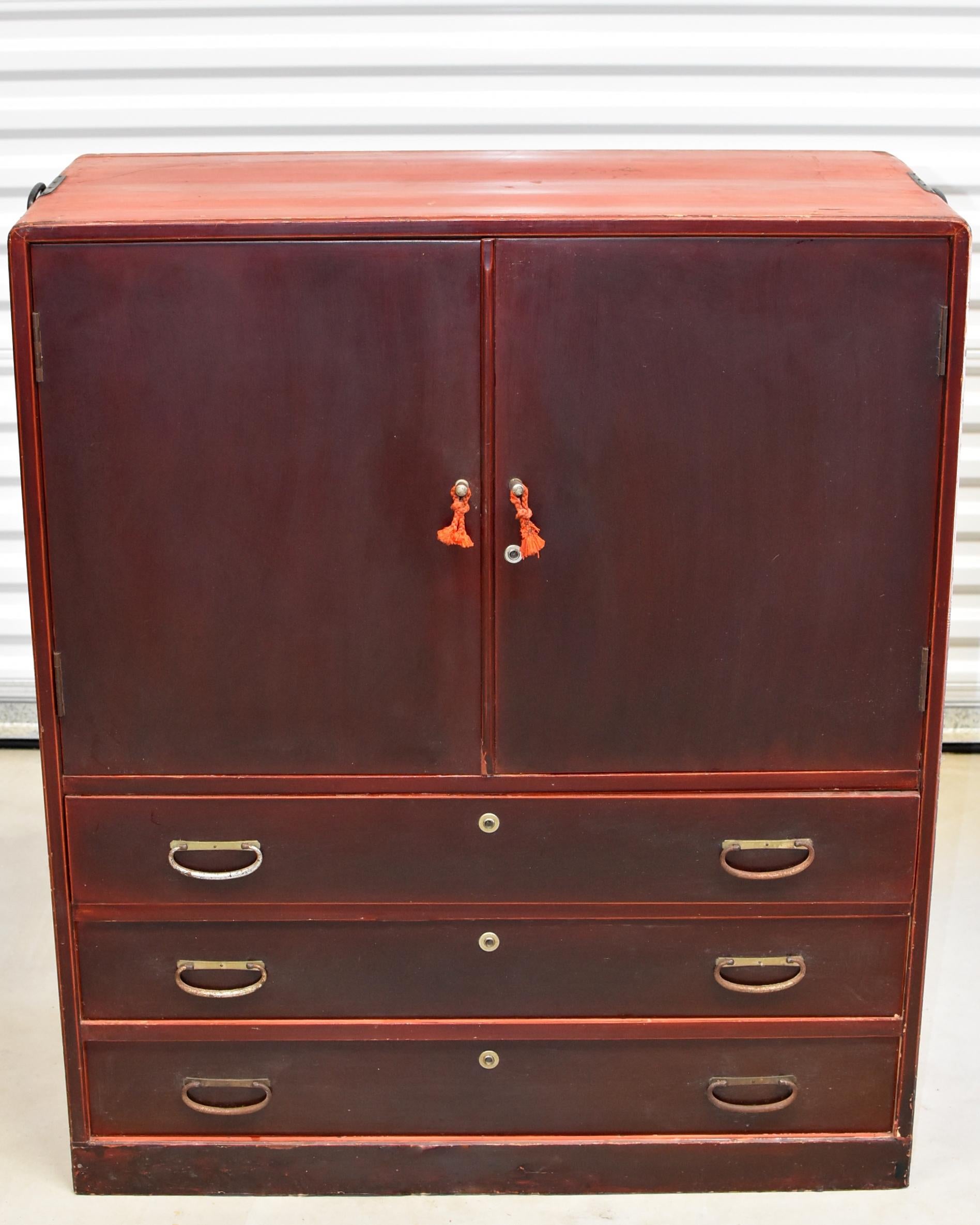 A beautiful vintage round corner Japanese Tansu with four shallow pullout trays and three full capacity drawers. The finish is an unique reddish hued brown, with the contrast from the brass hardware creates a fantastic visual impact. Retractable