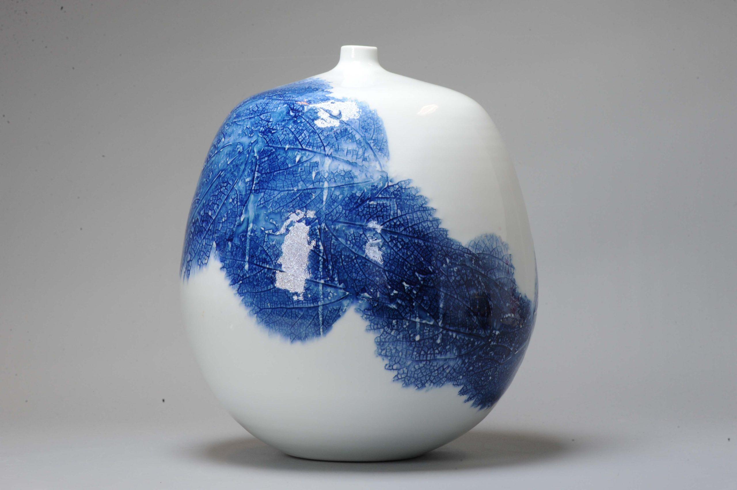 Belle et rare pièce.

Un superbe vase en porcelaine bleu et blanc, avec un tourbillon de feuilles. Fabriqué par Fuji Shumei

Fujii La spécialité de M. Aki Fujii est la technique consistant à dessiner une montagne en simulant les nervures d'une