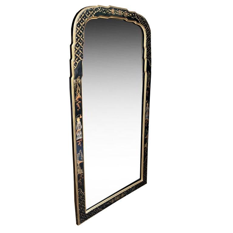 This is a beautiful vintage chinoiserie Queen Anne-style wall mirror. The mirror is made from wood and features a black lacquered or japanned background with an ornate hand-painted chinoiserie design around the edges. The design on the frame