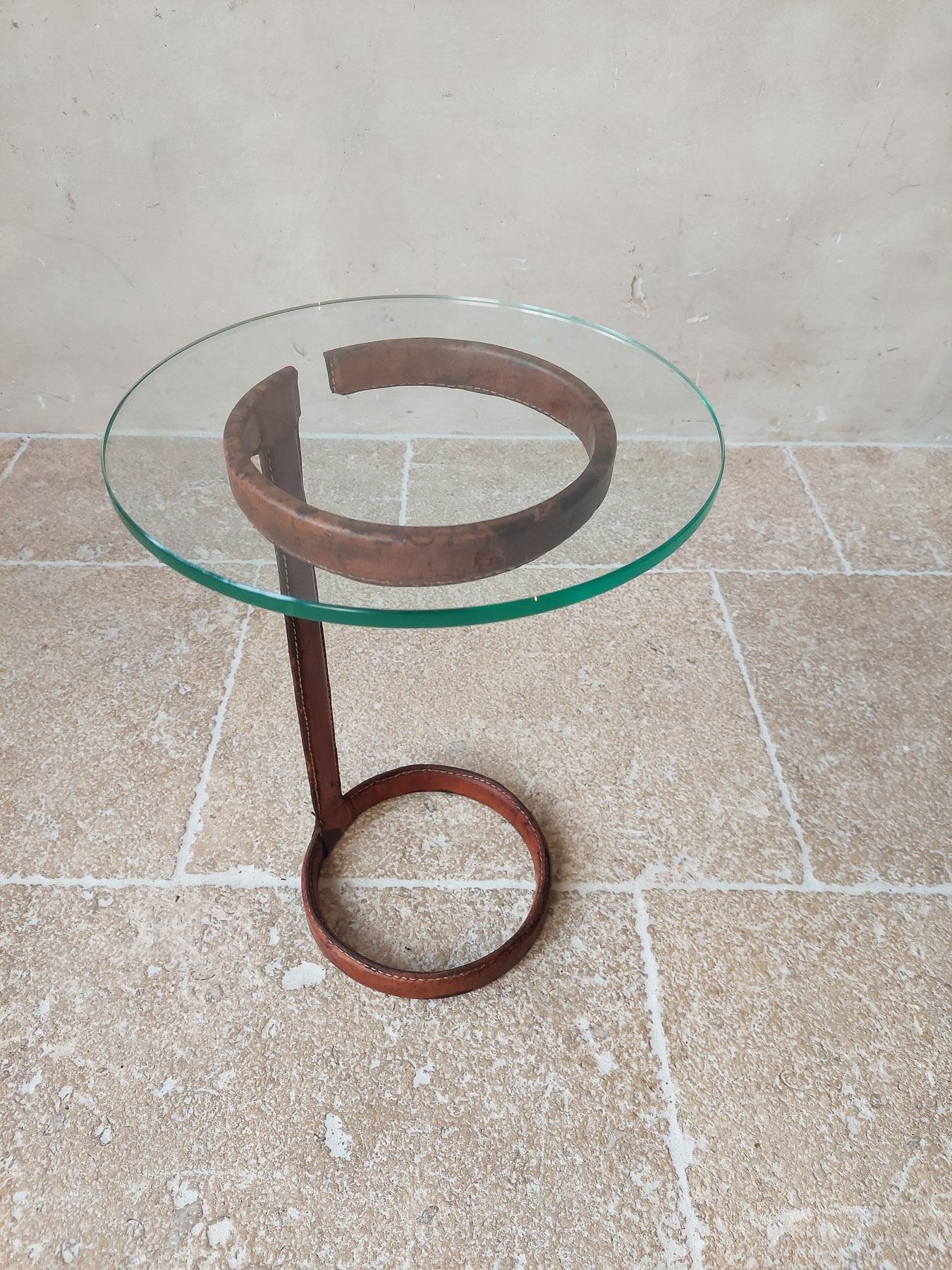 Vintage Jaques Adnet side table in leather and glass. Round table with cognac-coloured leather foot (iron covered with leather), and 1 cm thick polished glass top.

h 41 x diameter 30 cm
diameter foot 19 cm