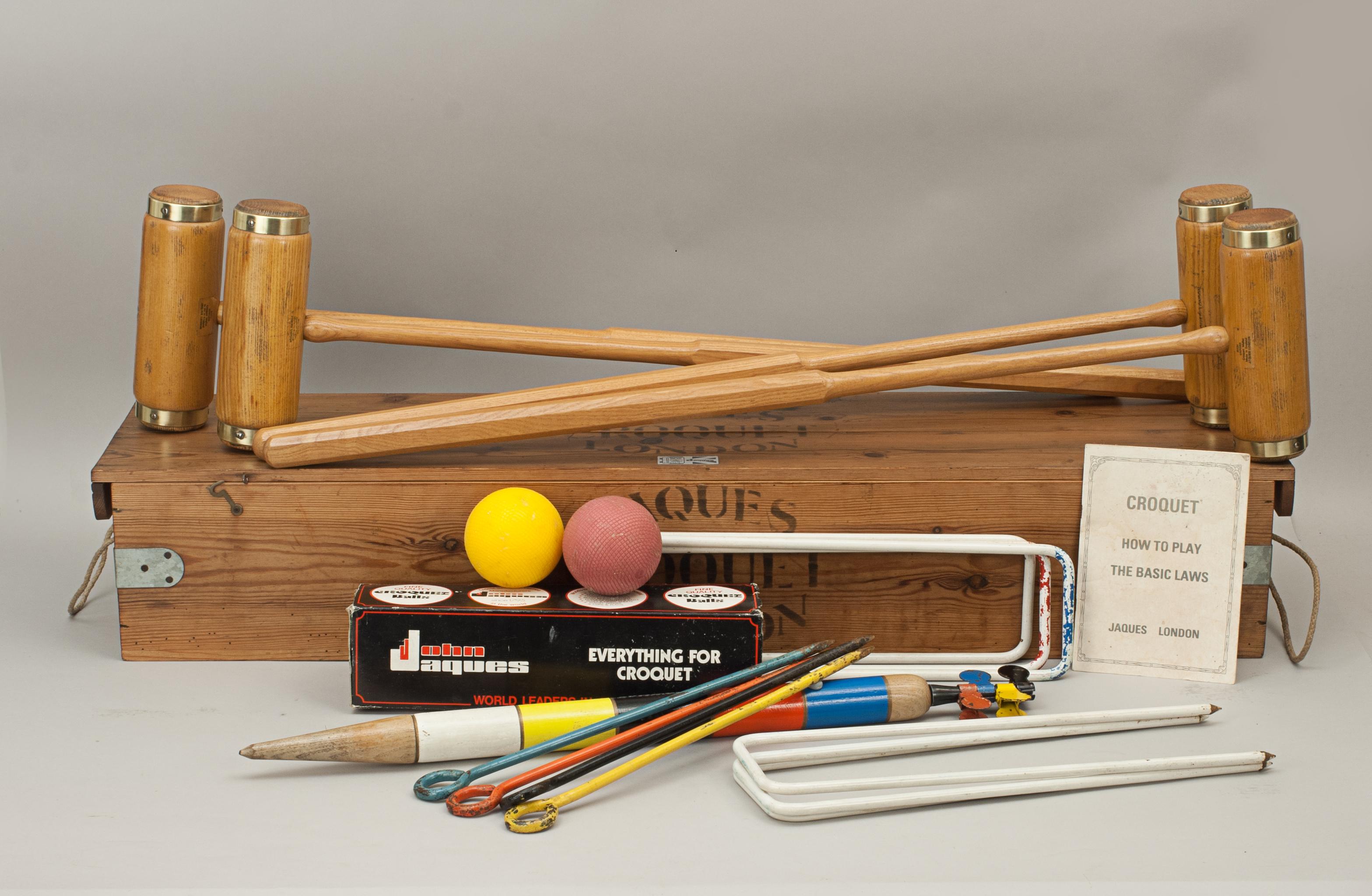 Jaques 'Oxford' Croquet set.
A Jaques garden croquet set in original pine box with four brass bound ash mallets. To complete the set there are four coloured balls in the standard croquet colors, six bent metal hoops, four sprung clips, four colored