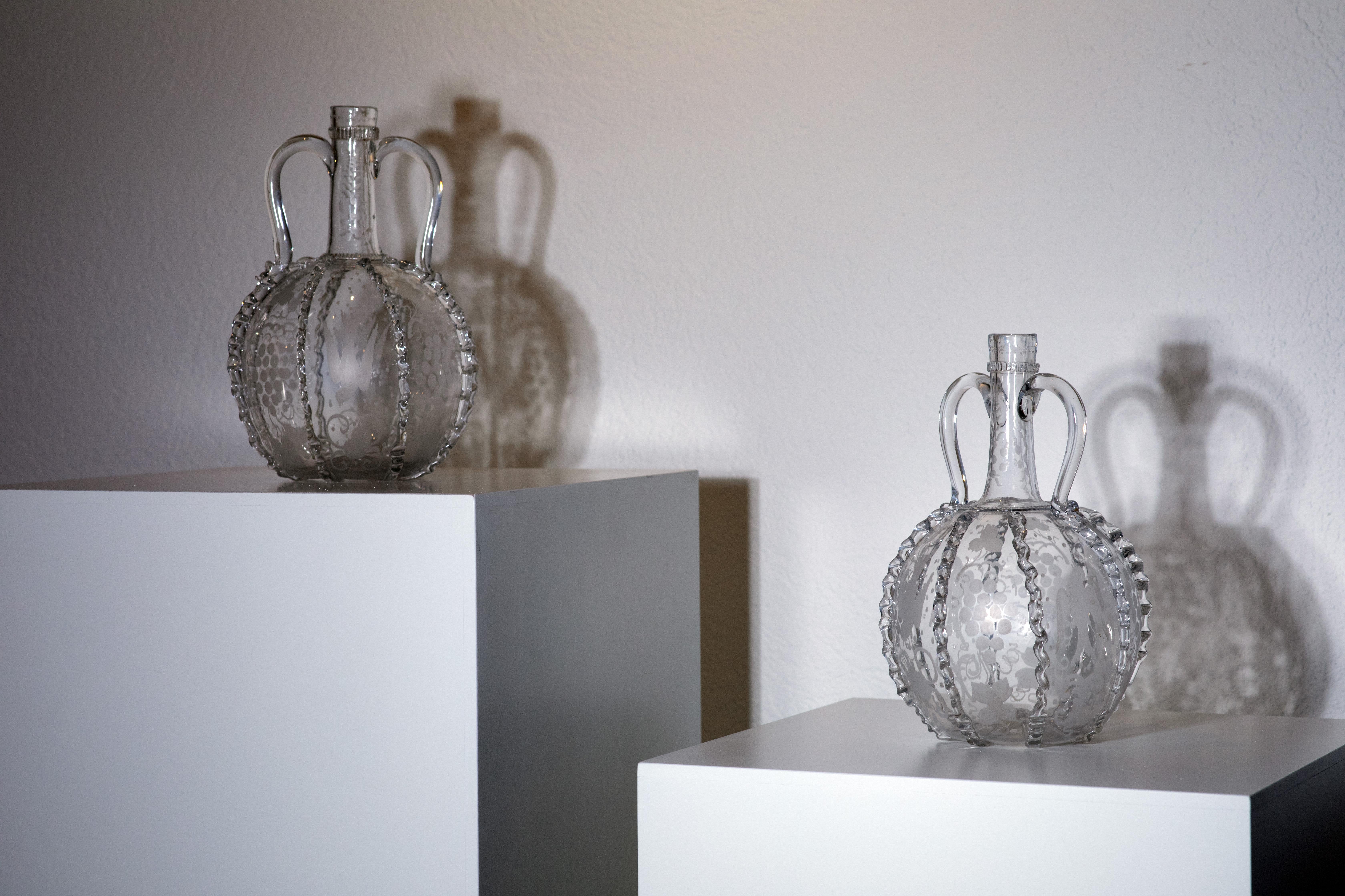 This charming set of two vintage Italian glass jars from the late 19th to early 20th century is a perfect example of the elegance and craftsmanship of the era. The hand-blown glass gives each jar a unique character, with smooth, rounded forms and a