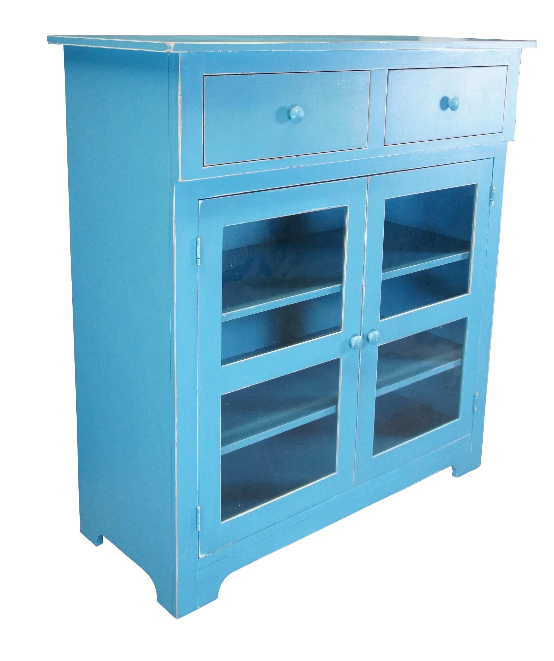 A beautiful blue cupboard by Jasper Cabinet Company.  Made from hardwood with two dovetailed drawers over lower cabinet with adjustable shelves.  The lower doors feature antiqued glass.  A unique design inspired by American Jelly Cabinets from the