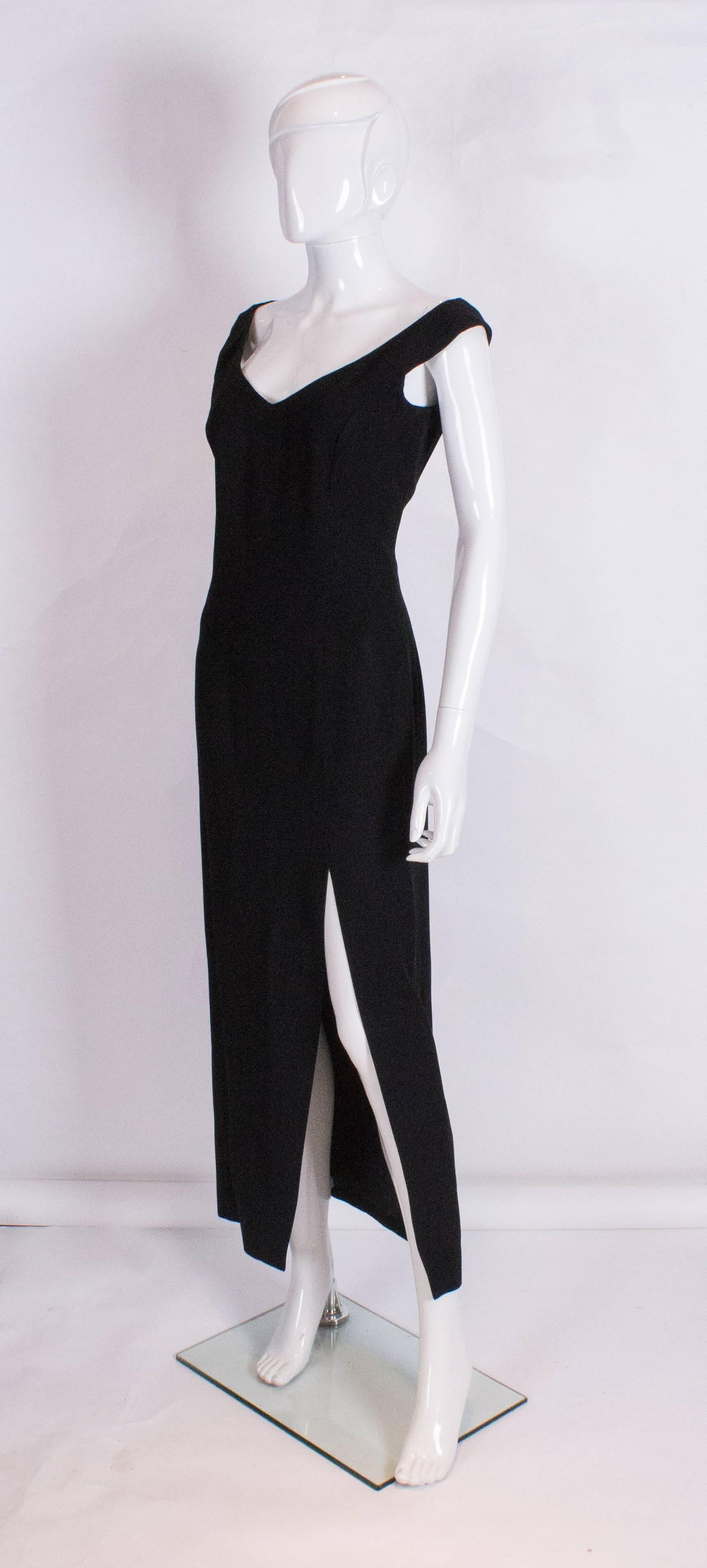 A chic and elegant evening vintage  gown by Jasper Conran .The dress is in a black crepe with an off the shoulder neckline and 23'' slit at the front. It has a central back zip and is fully lined.